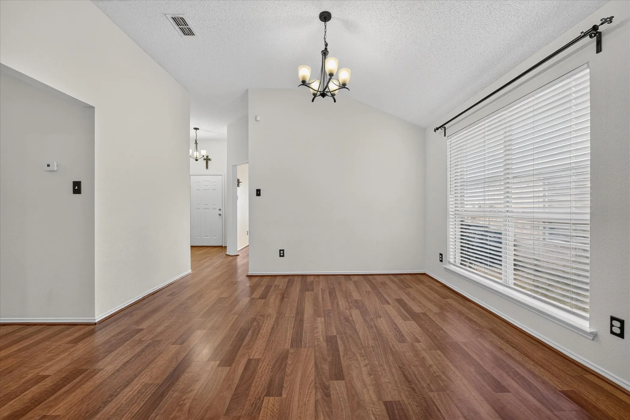 Bright dining area adjacent to the kitchen, complete with modern light fixtures and expansive windows offering abundant natural daylight.