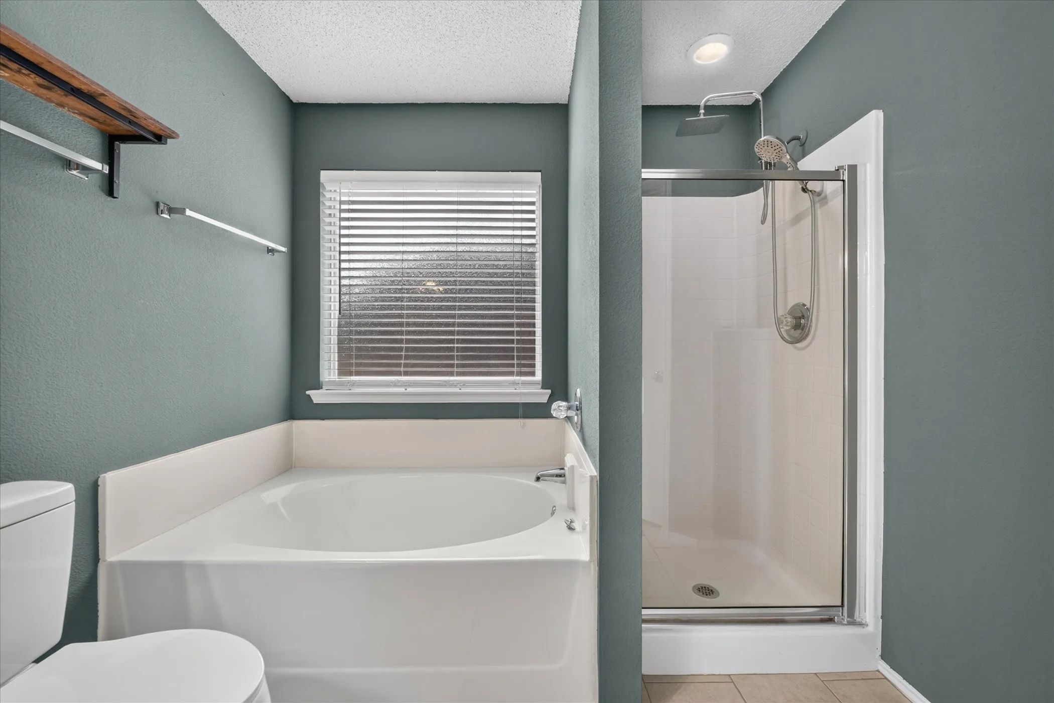 Full secondary bathroom equipped with a functional tub/shower combination, clean tile work, vanity storage, and crisp neutral tones.