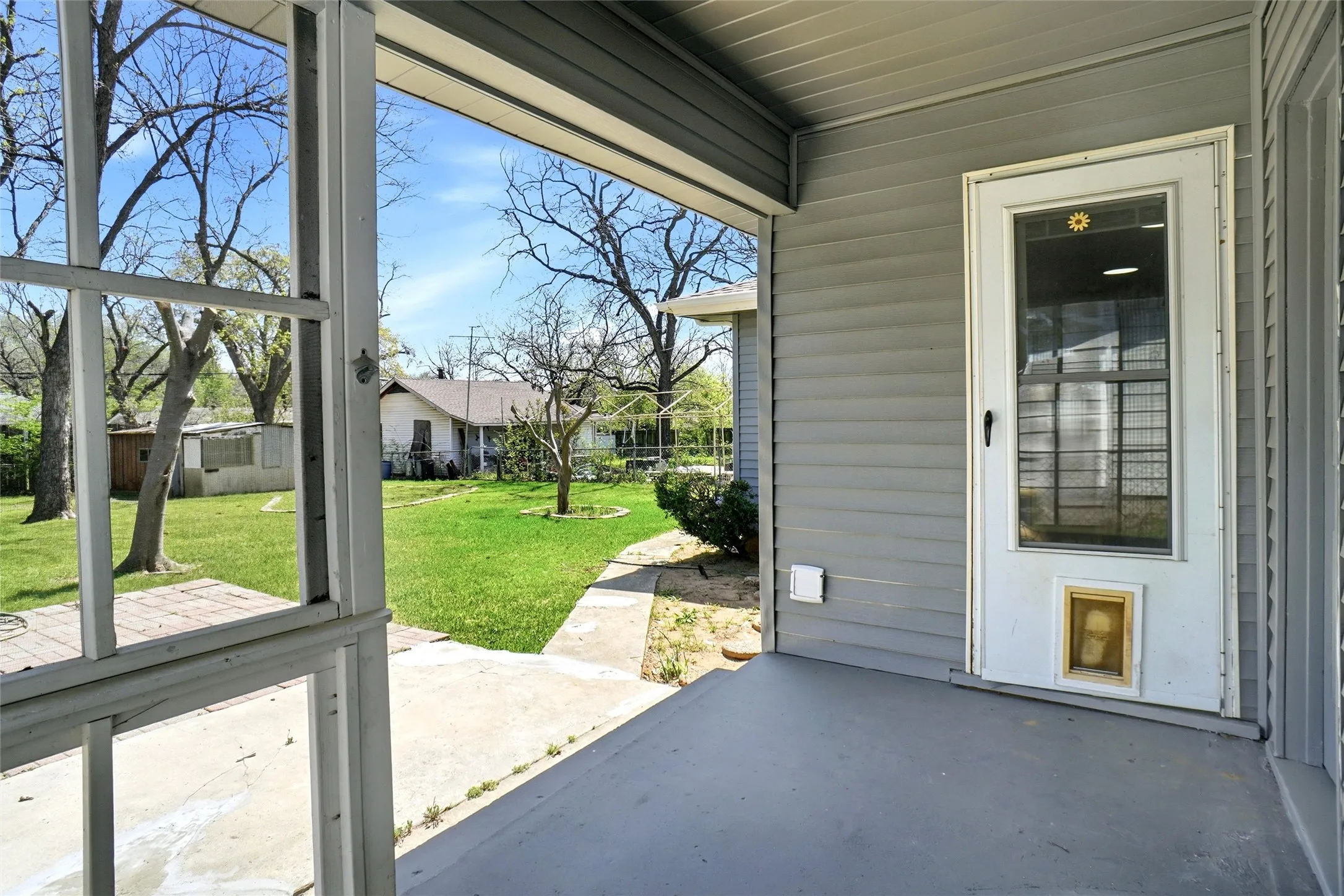 covered rear porch with storm door into kitchen and pavestone patio deck extension
