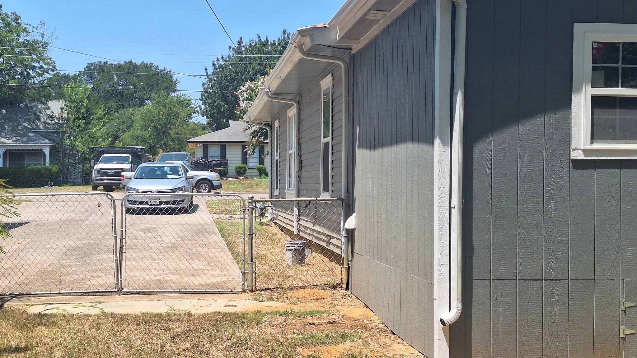 2nd 30 ft long driveway on right side of home with chain link gate at end into backyard