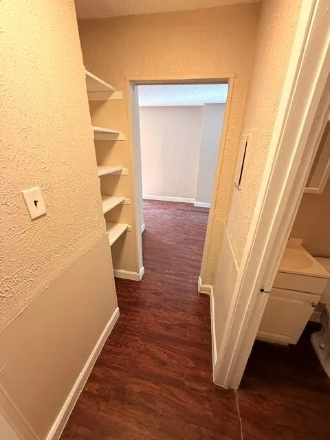 Built-in shelving, wood-finish flooring, and light-toned walls