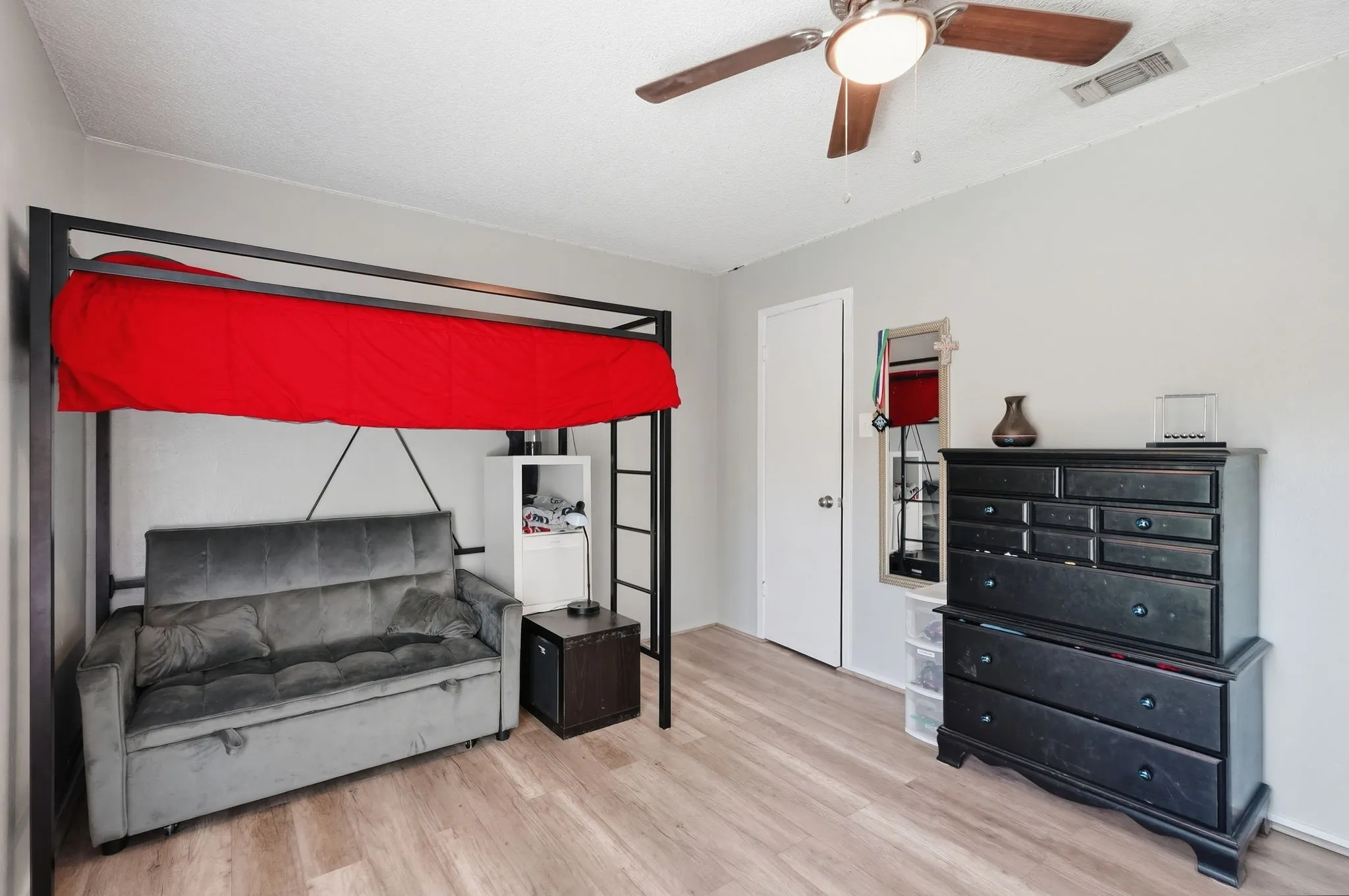 Wood-finish flooring, ceiling fan with light fixture, and white painted walls