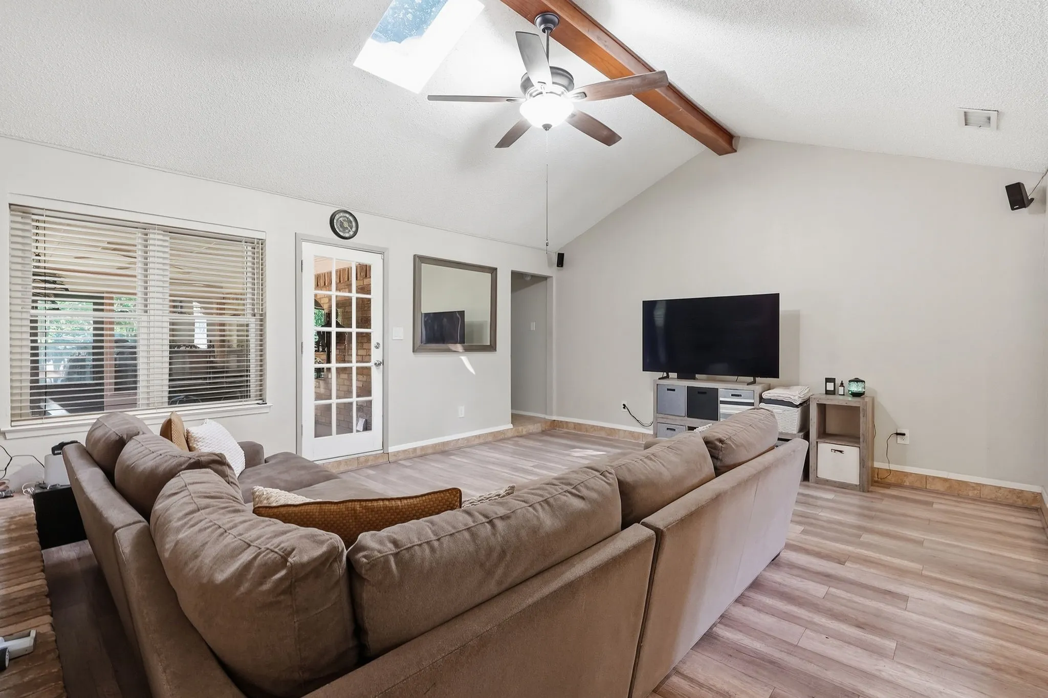 Vaulted ceiling with exposed wood beams and a ceiling fan