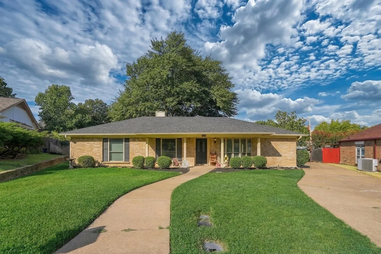 Brick exterior with a dark shingle roof and a covered entry