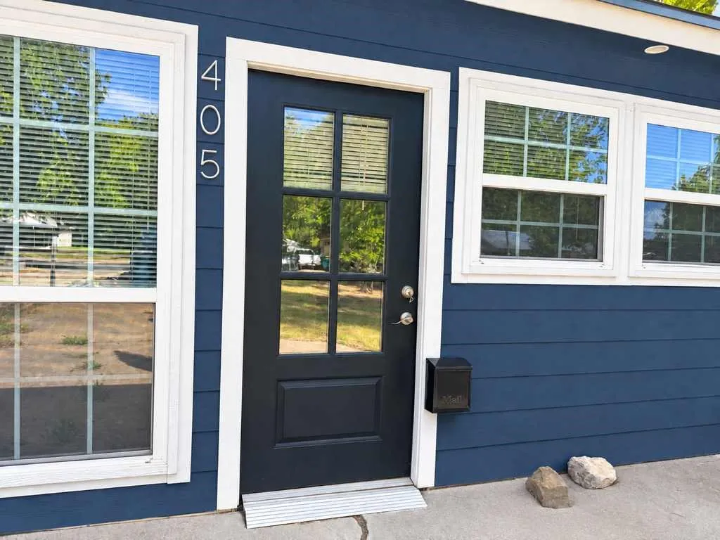 Clean navy exterior, contrasting white trim and a glass-paneled front entry.