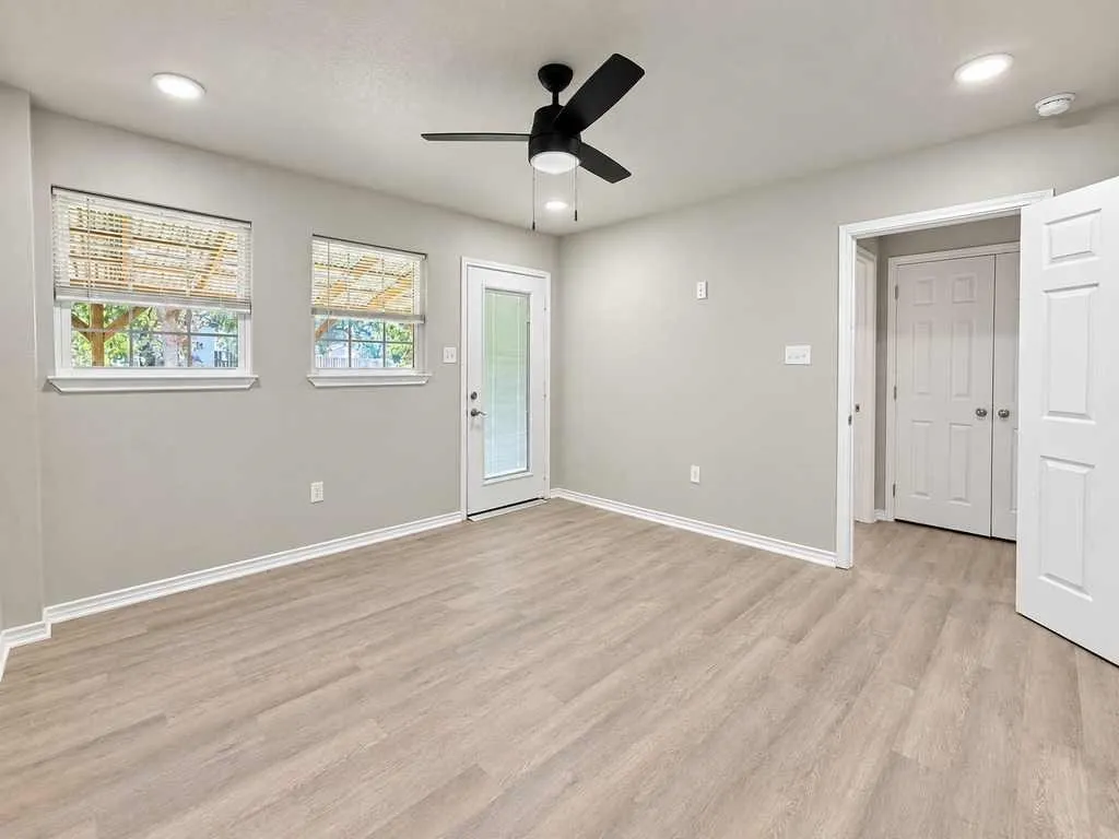 Bright, flexible room with multiple windows, ceiling fan and direct exterior access.