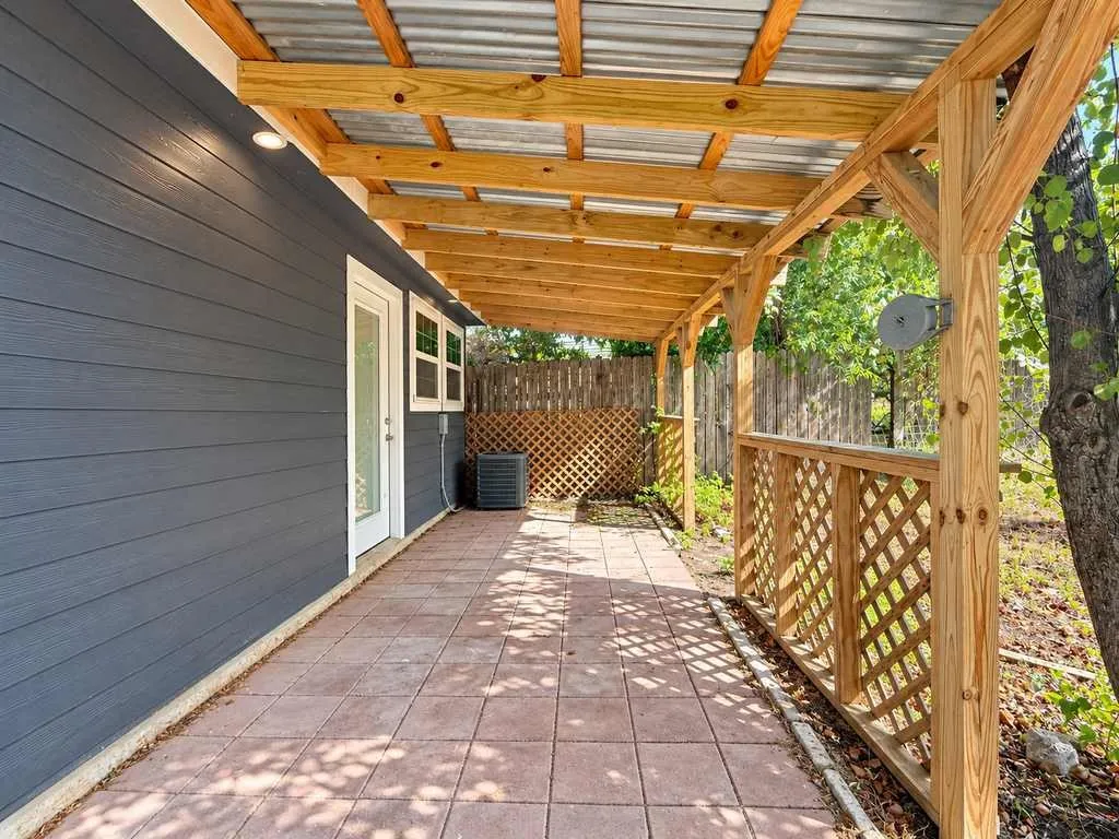 Shaded outdoor area with metal roofing and wood-framed construction overlooking the yard.