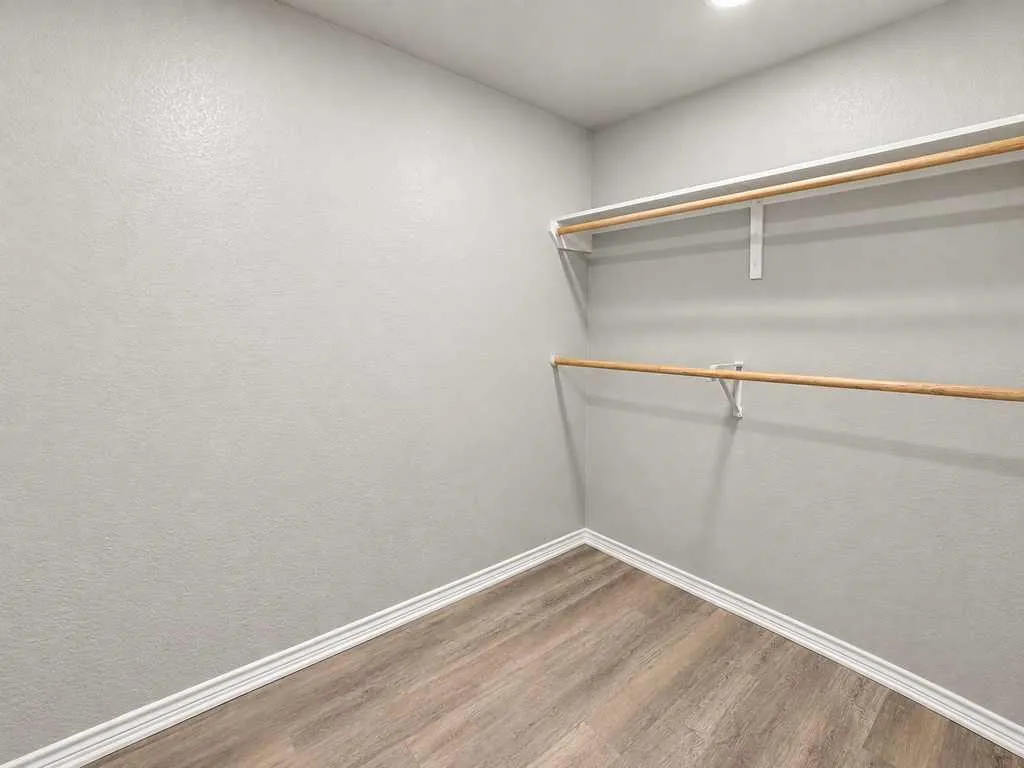 Generous closet space with multiple hanging areas and shelving.
