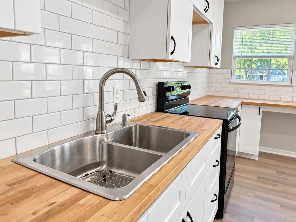 Double-basin sink, butcher-block countertops and subway-tile backsplash create a clean, functional workspace.