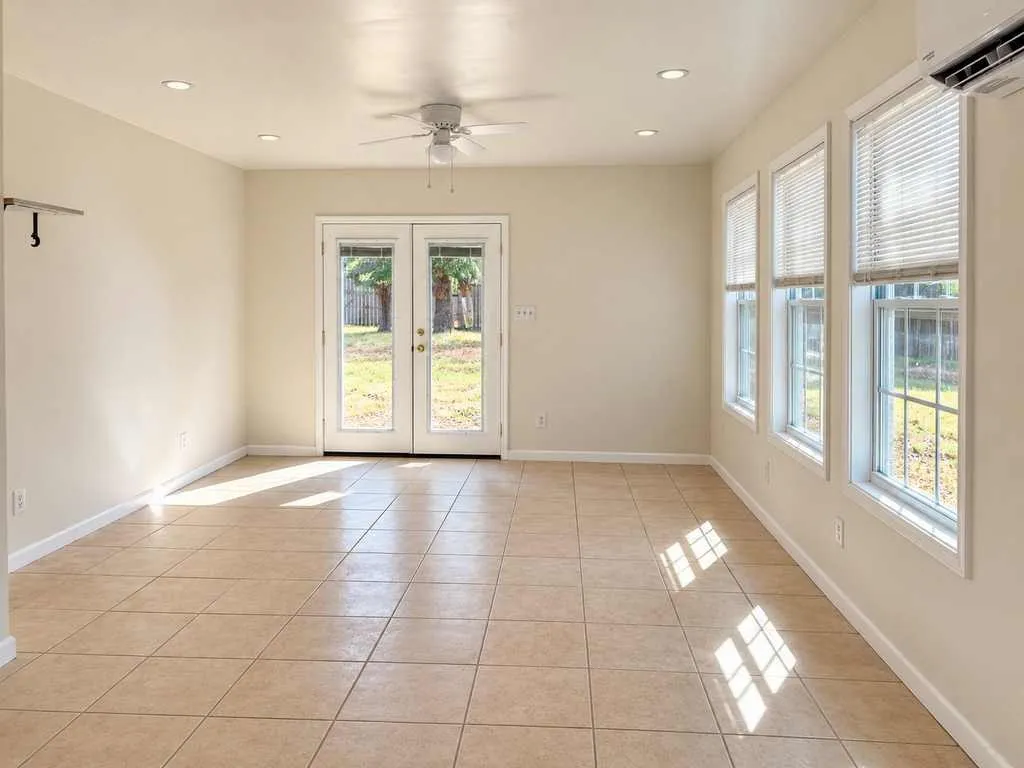 Multiple windows and French doors bring natural light into the spacious open room.