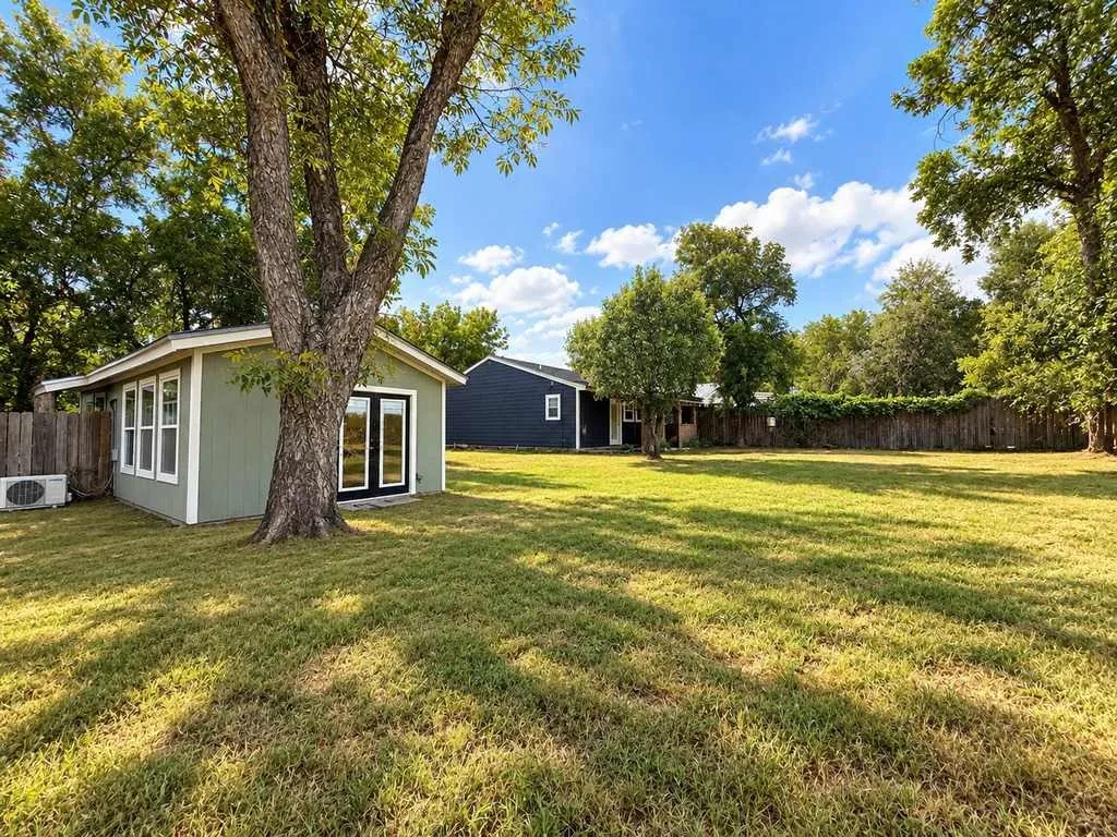 Wide backyard view highlights the separate residences, mature trees and unusually generous in-town lot.