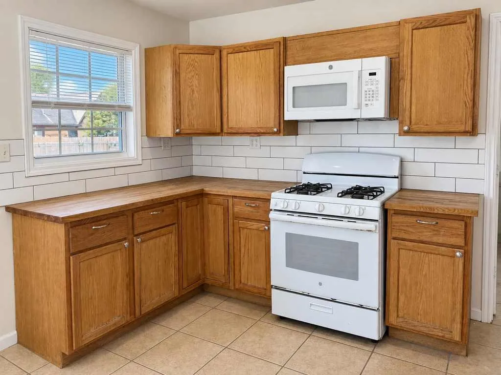 Wood cabinetry, butcher-block countertops, subway-tile backsplash and gas range.