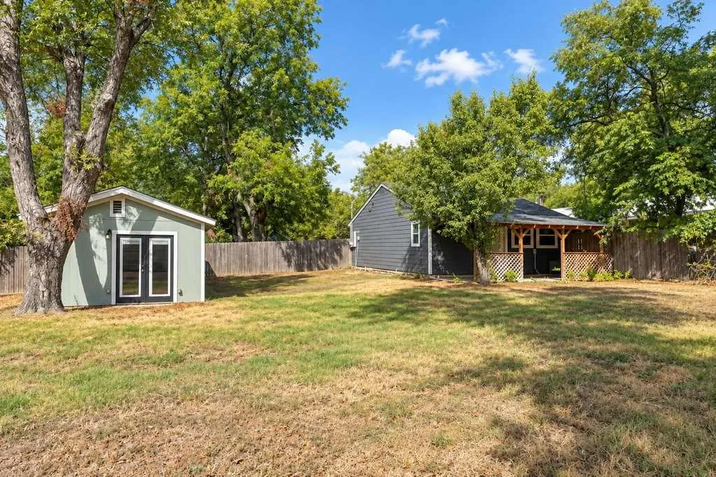 View across the property showing the separate residences, mature trees and open yard between them.