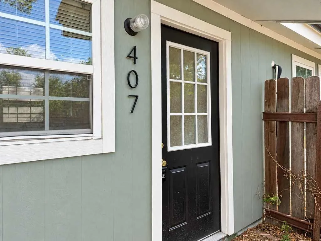 Private entry with sage exterior, white trim and contrasting black door.