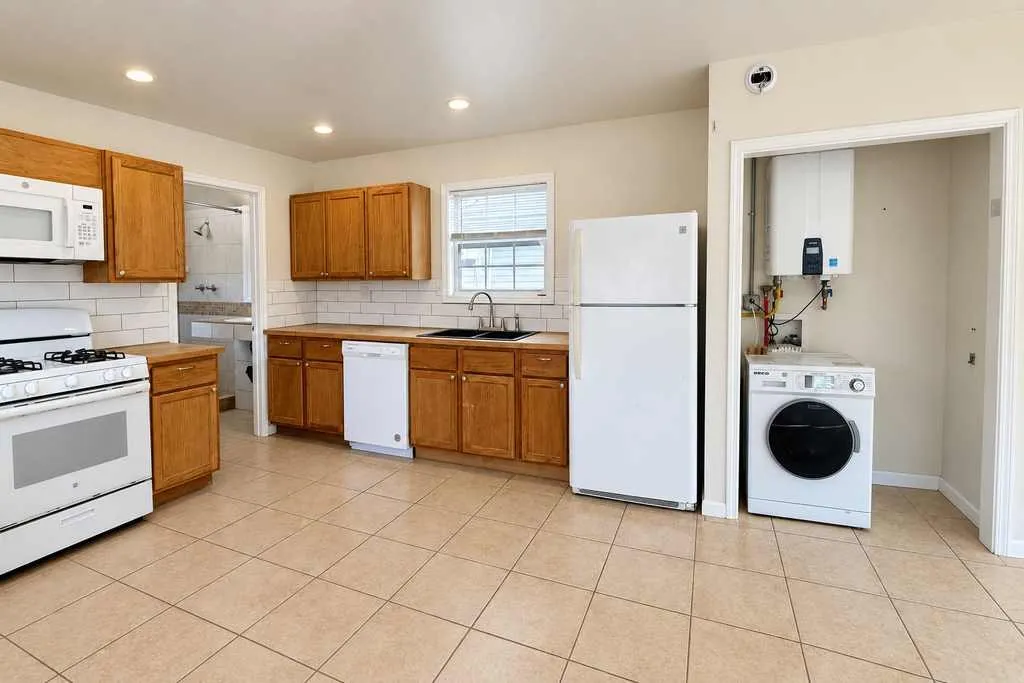 Kitchen appliances, cabinetry and a dedicated laundry nook are conveniently arranged within the open floor plan. Laundry appliance shown does not convey.