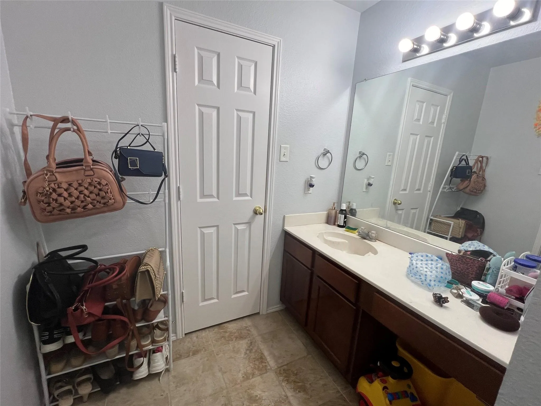 Single vanity with an integrated sink, extended countertop, and wood-finish cabinetry