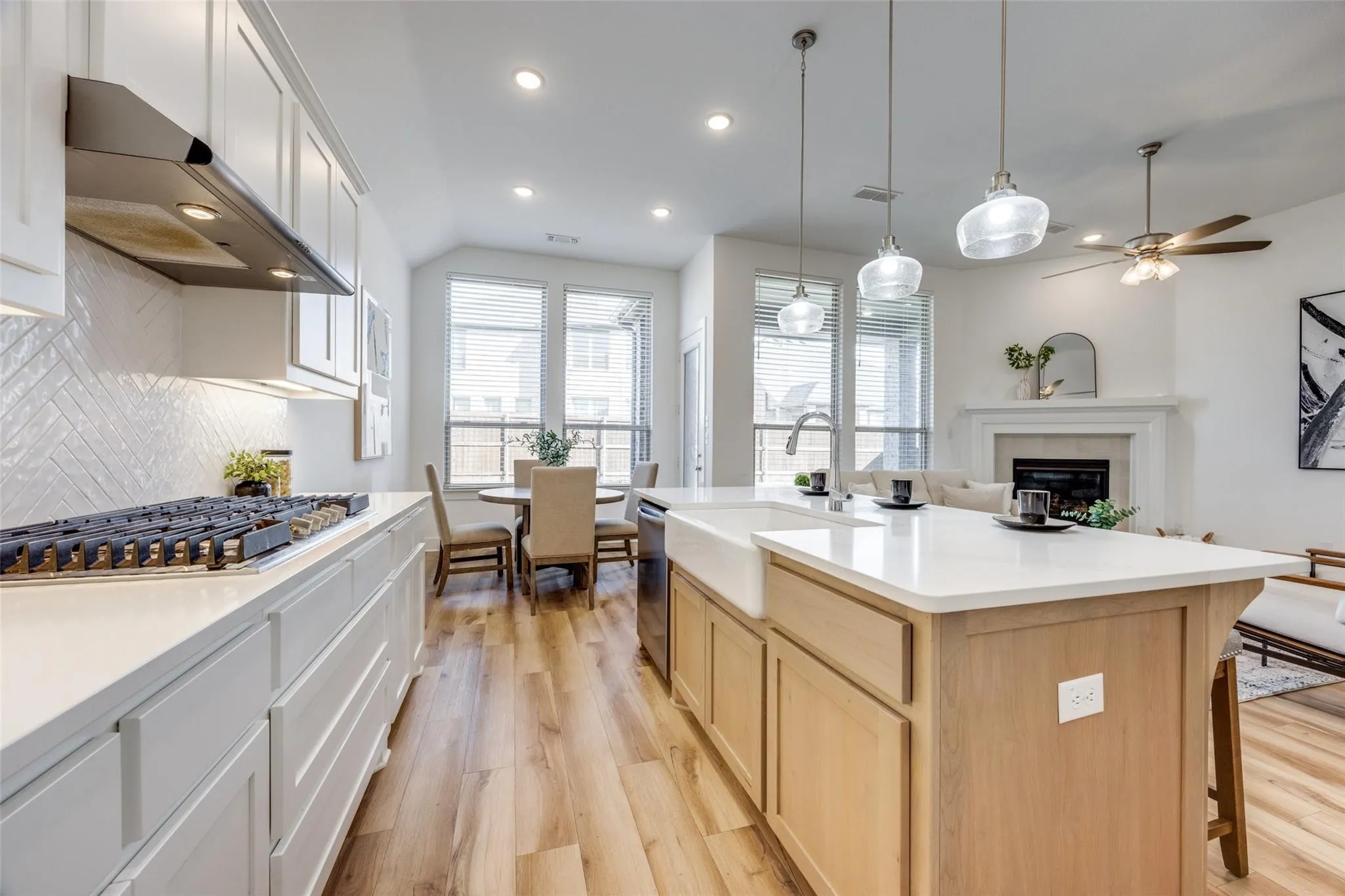 Kitchen with stainless steel appliances, light wood finished floors, light brown cabinetry, recessed lighting, and under cabinet range hood