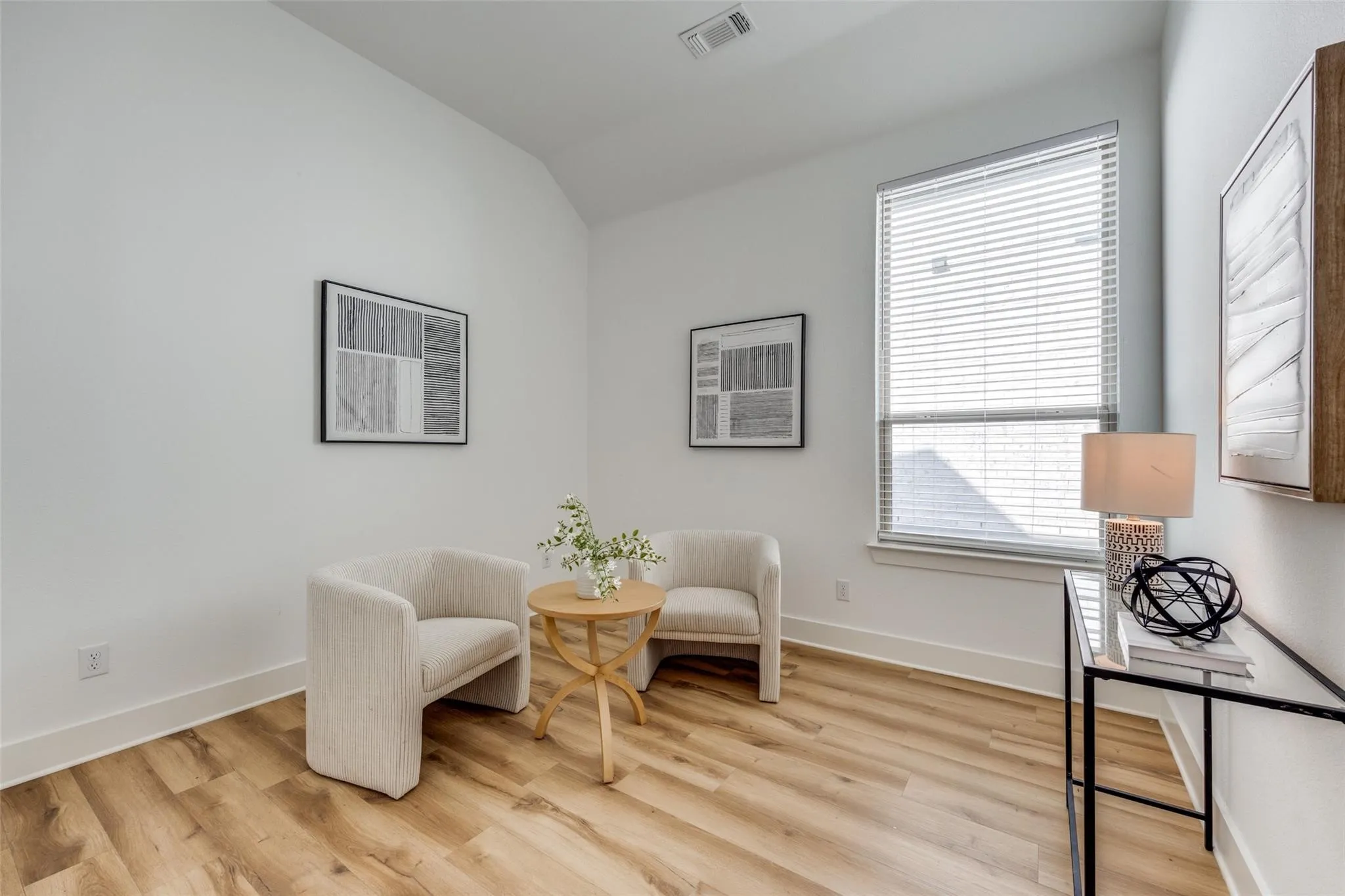 Sitting room featuring light wood finished floors and vaulted ceiling