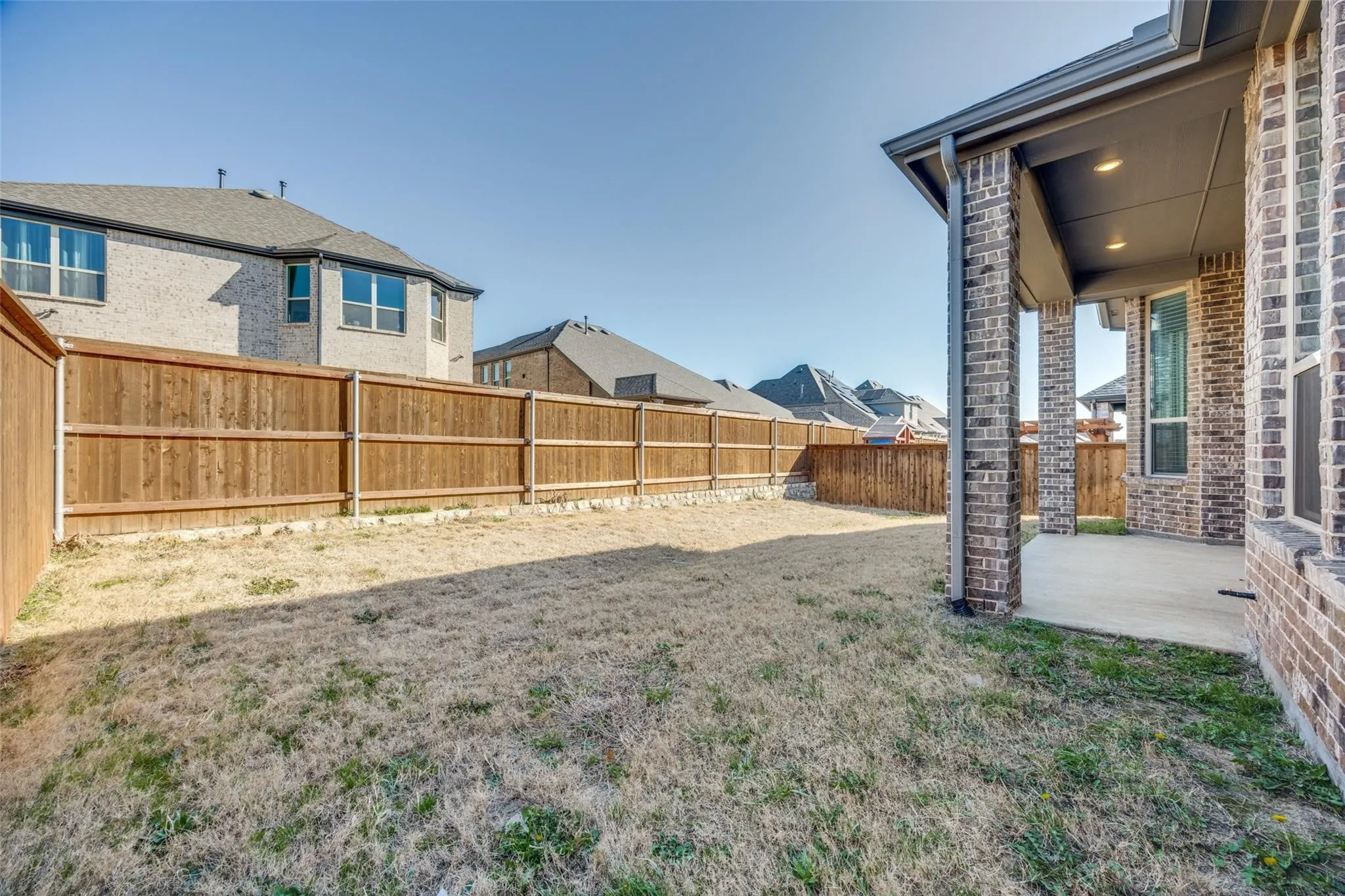 Fenced backyard with a patio area and a residential view