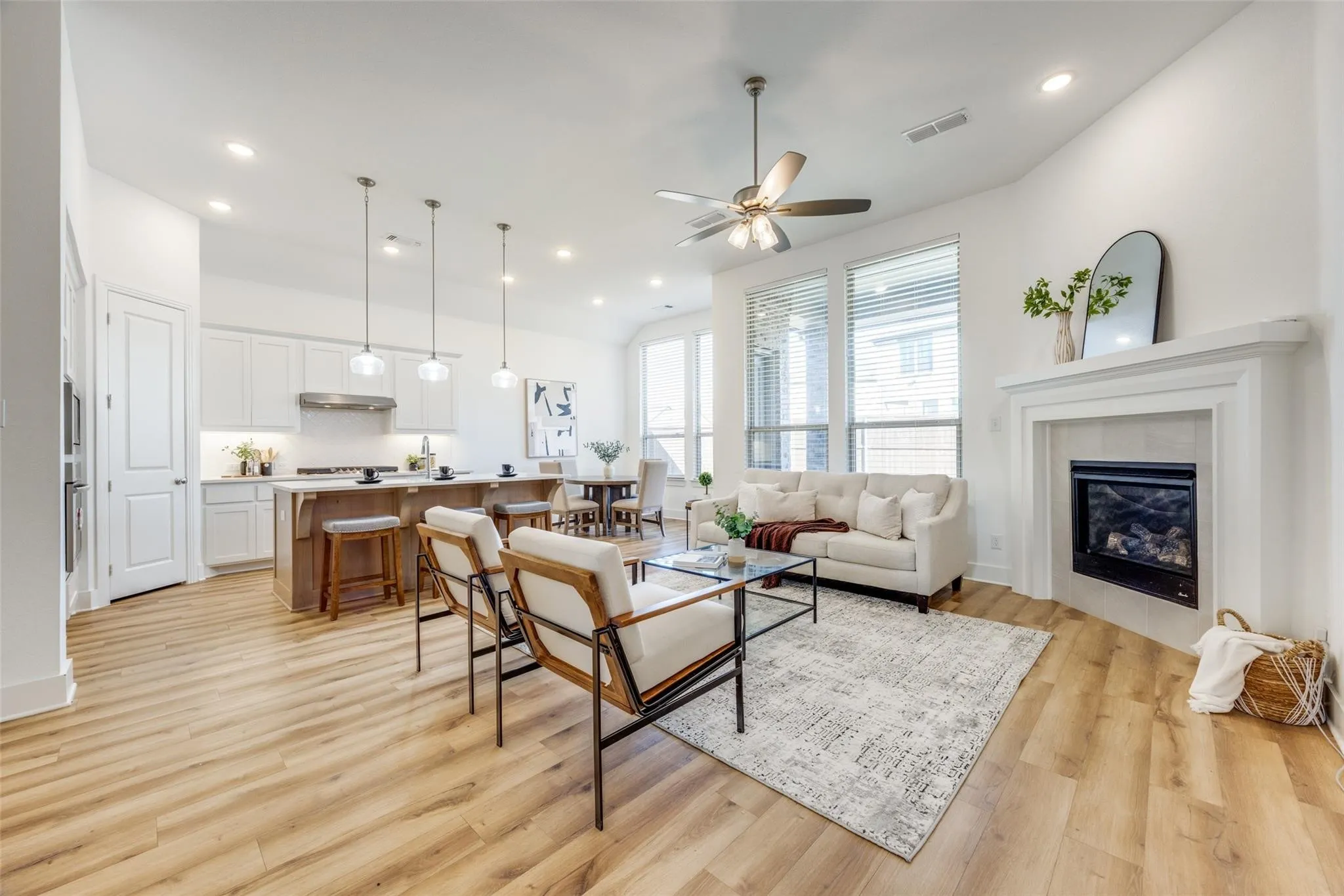 Living area with light wood-style floors, recessed lighting, ceiling fan, and a tile fireplace
