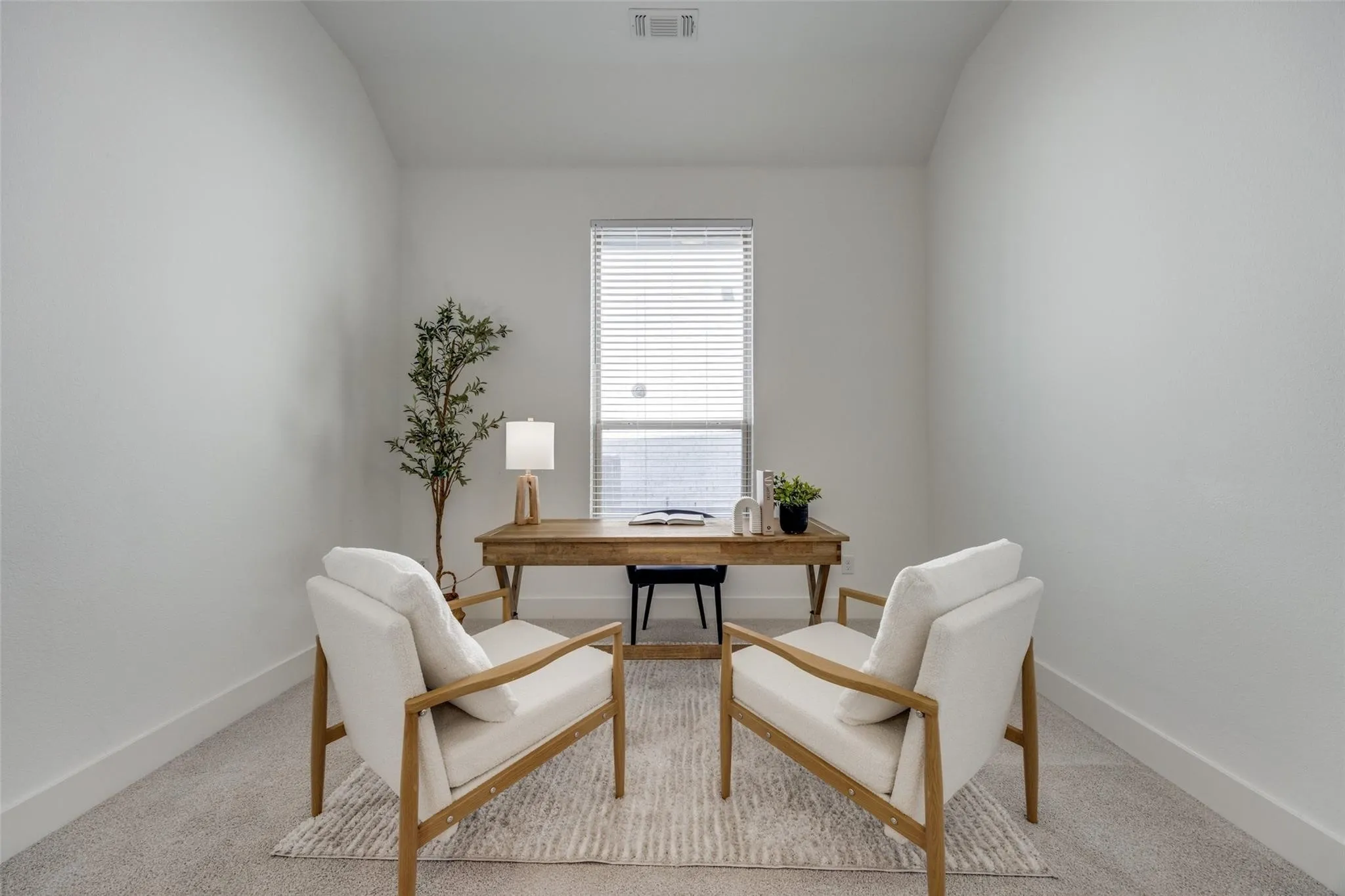 Office with carpet flooring and vaulted ceiling