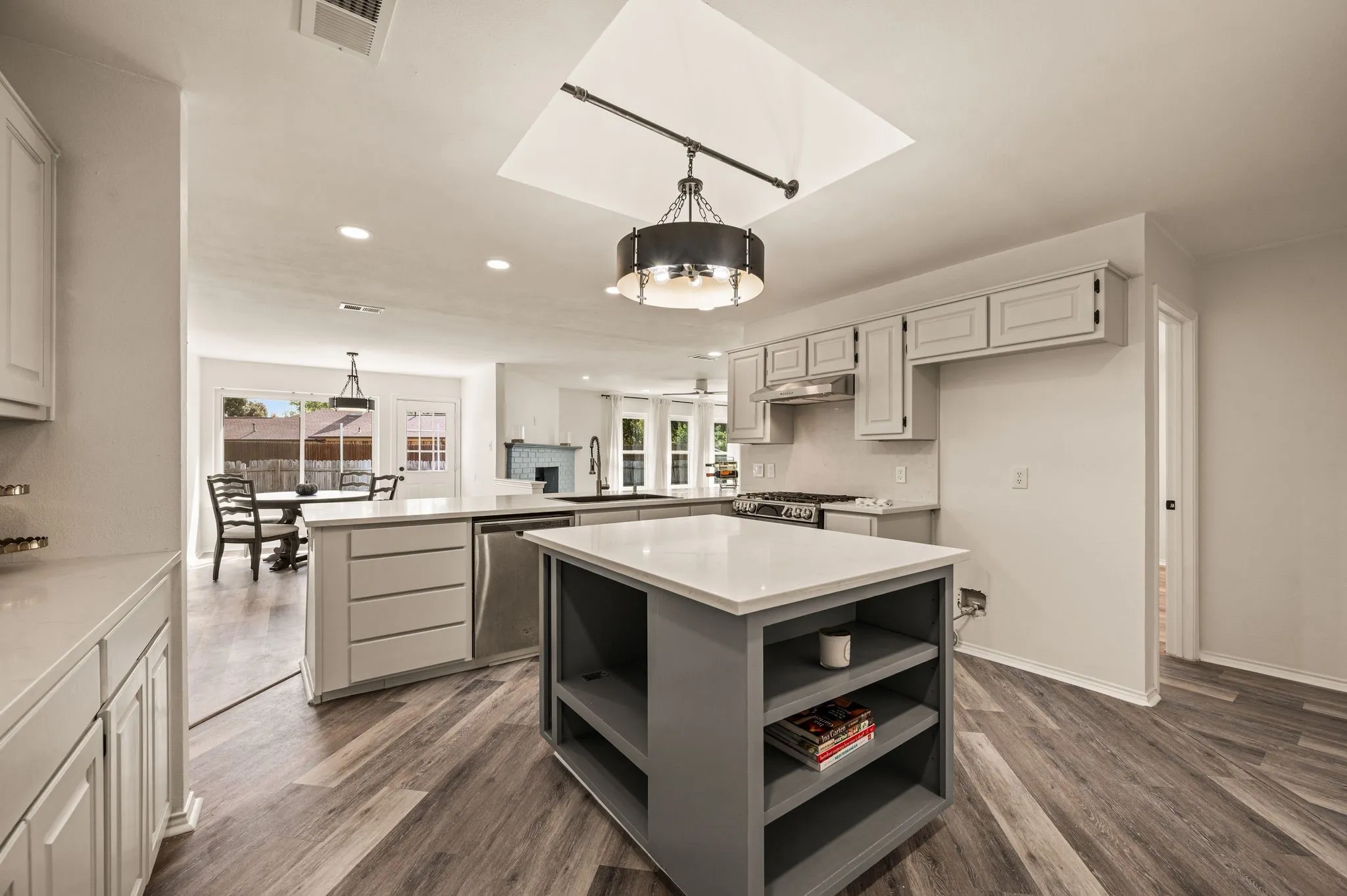 Kitchen featuring a central island, wood-finish flooring, recessed lighting, and a skylight