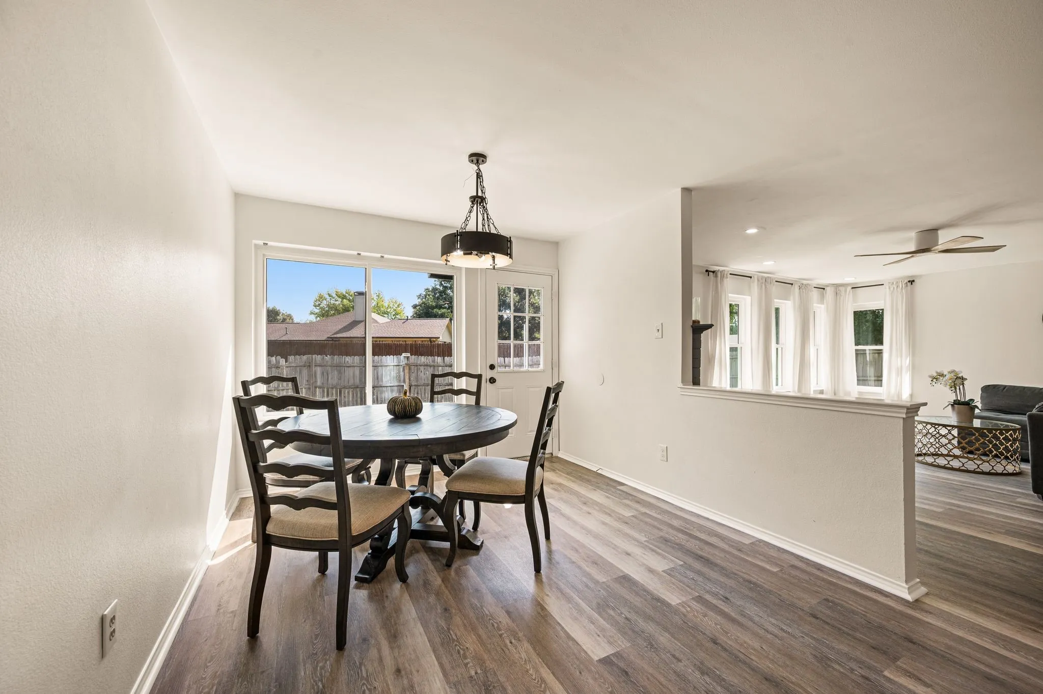 Wood-finish flooring throughout, a pendant light fixture, and an exterior door with a window pane