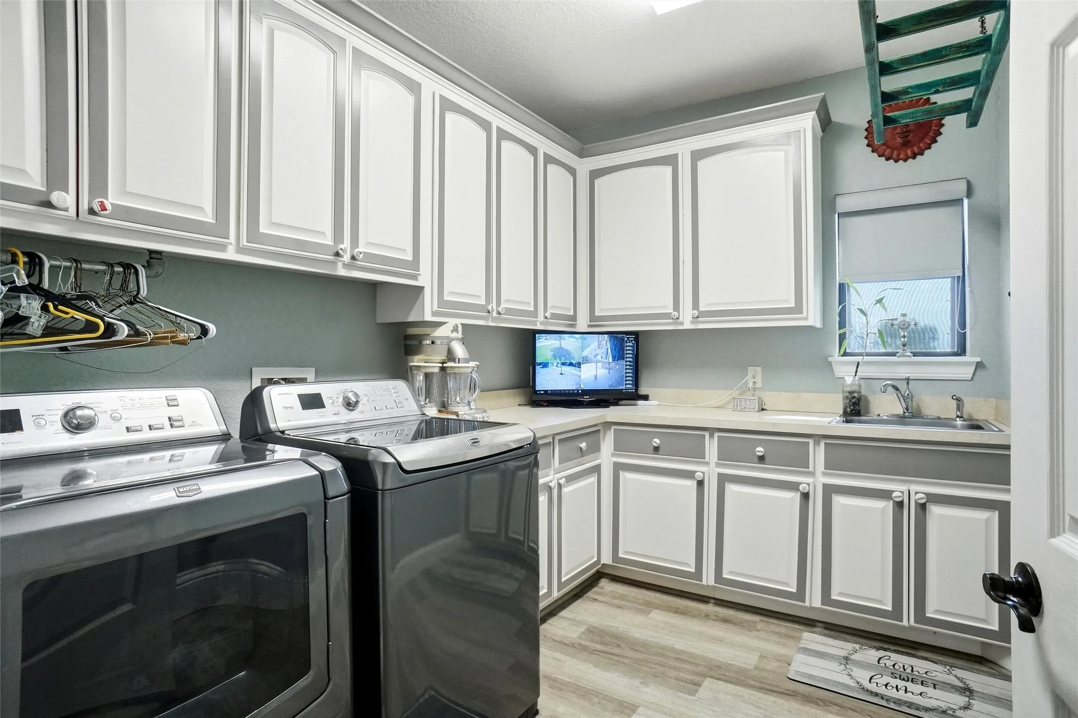 Laundry room with sink and drip area and plenty of storage and counter space.