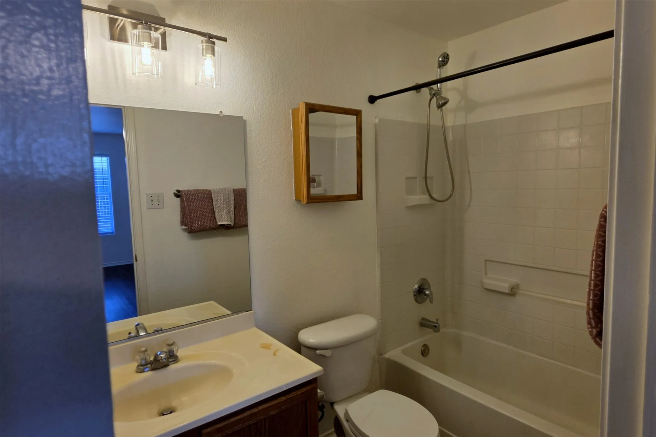 Primary bathroom with new lighting, new flooring, and its own medicine cabinet.