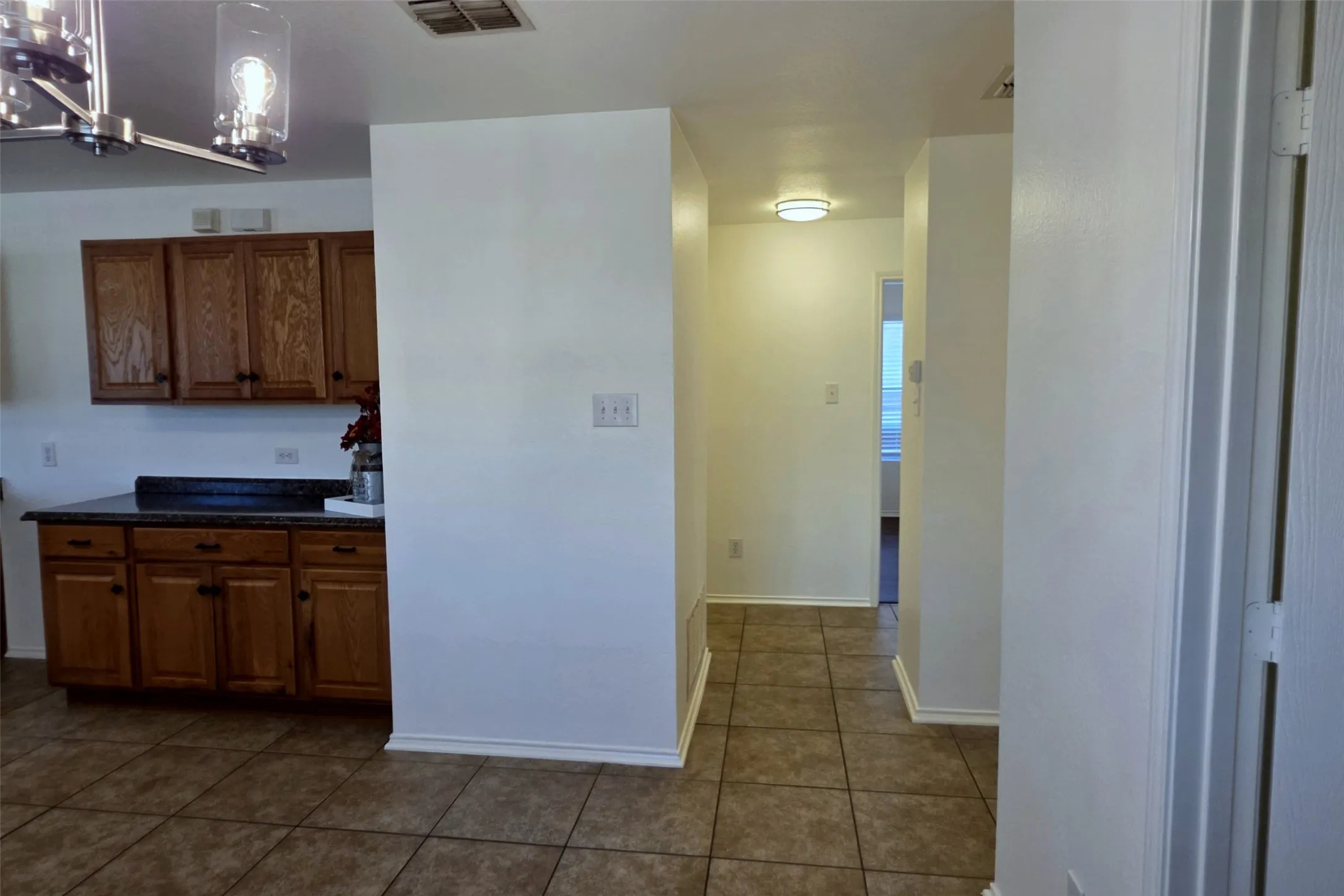 Split bedroom hallway with tile floors.