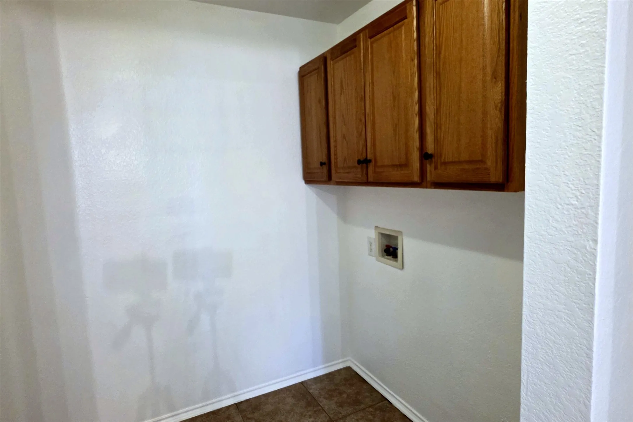 Separate utility room with tile floors and multiple built-in cabinets!