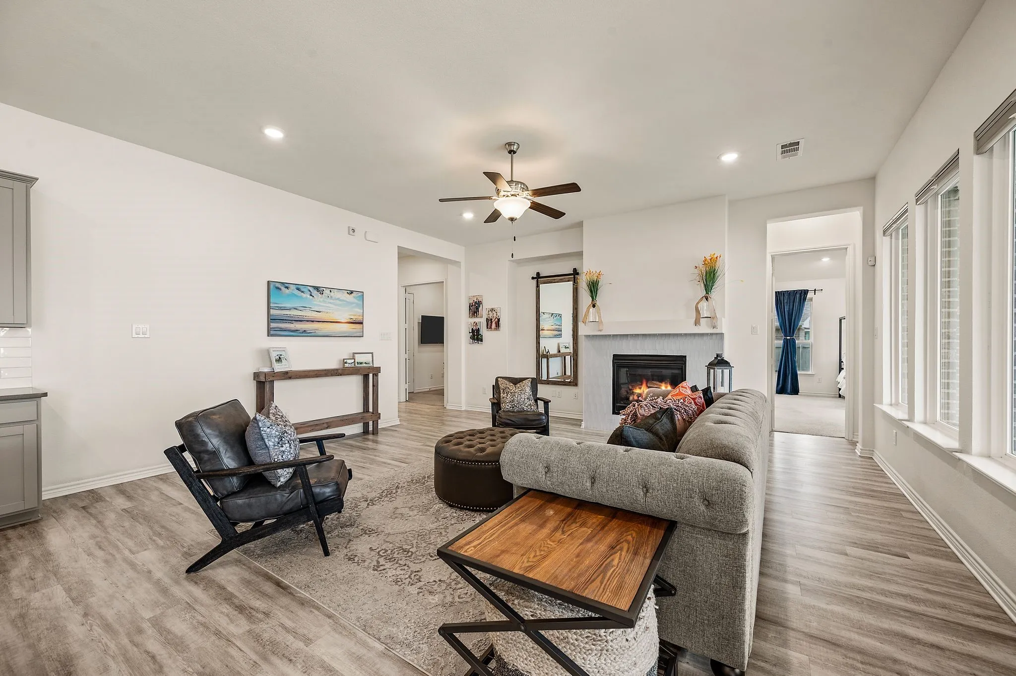 Recessed lighting, LVP flooring, a lovel fireplace with a beautiful  tile surround, multiple windows letting in wonderful lighting and a ceiling fan...More than enough room for all your friends and family!