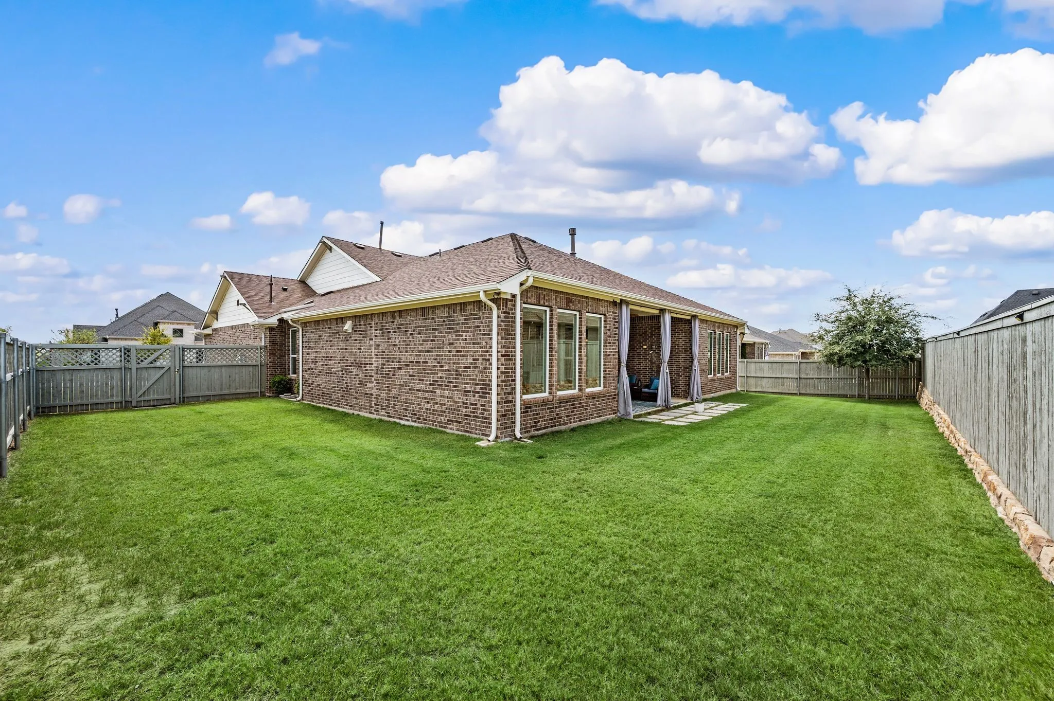 Expansive fenced backyard with a covered patio, and extended fence so you can enjoy more of the backyard and more privacy!