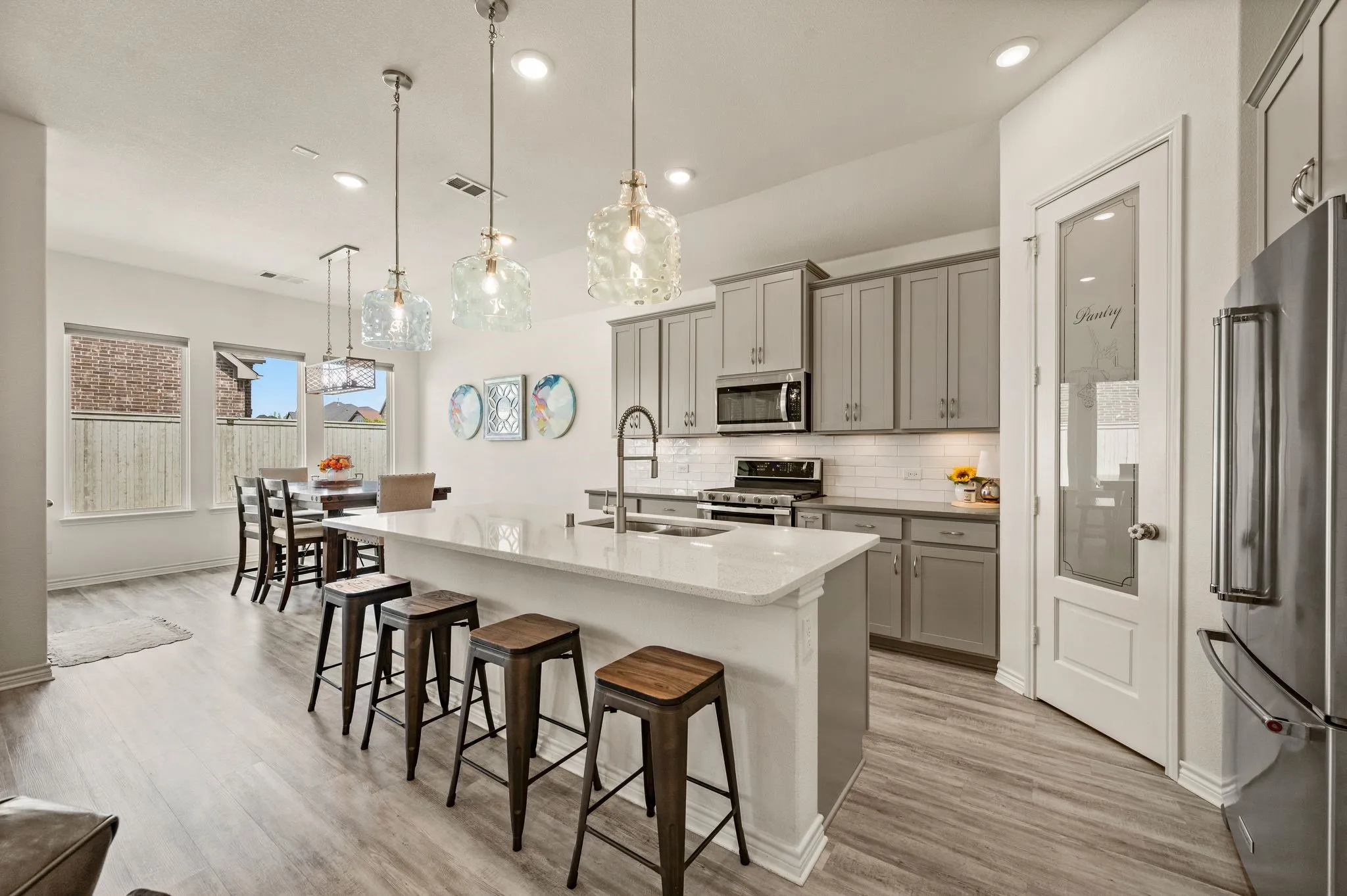 Open-concept kitchen featuring a wonderful island with seating, lots of cabinetry, stainless steel appliances, and LTV flooring.