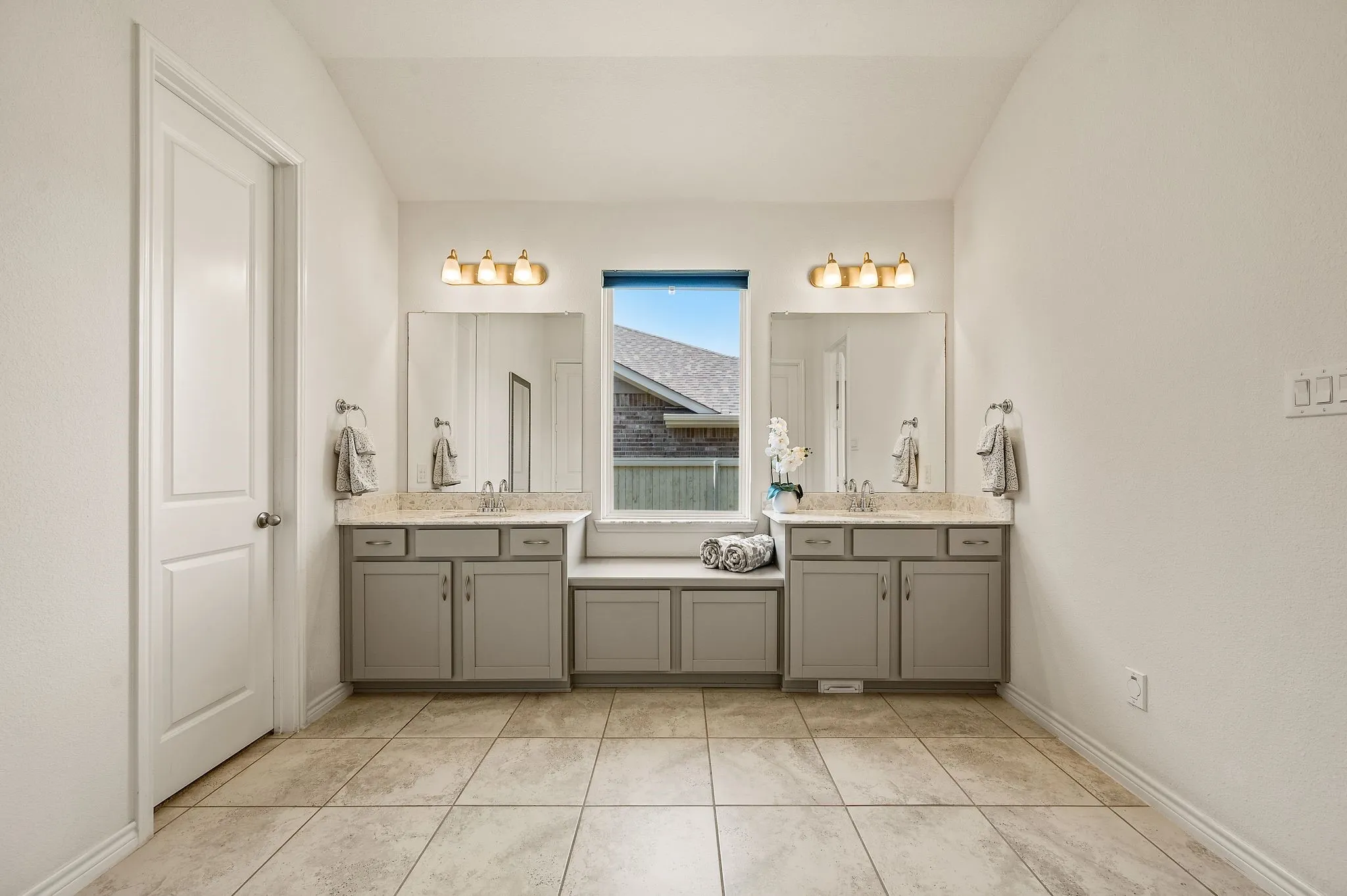 Dual vanity with integrated storage cabinetry, individual mirrors, and overhead light fixtures with more than enough space to enjoy your spa like primary bathroom.
