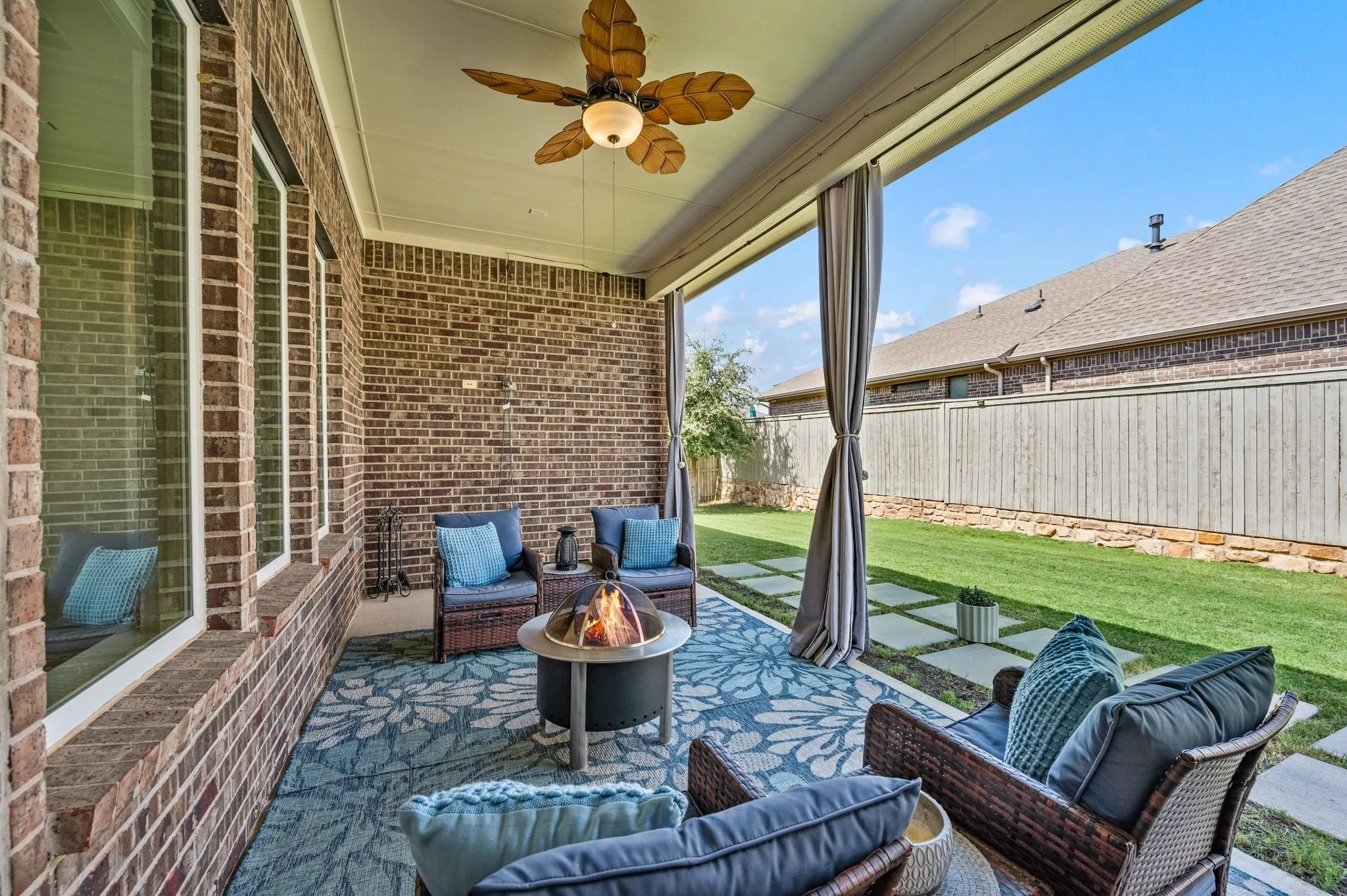Large covered patio featuring ceiling fan and a great space for furniture and a grill.  This space is shaded all day so you truly can enjoy your patio all day long.