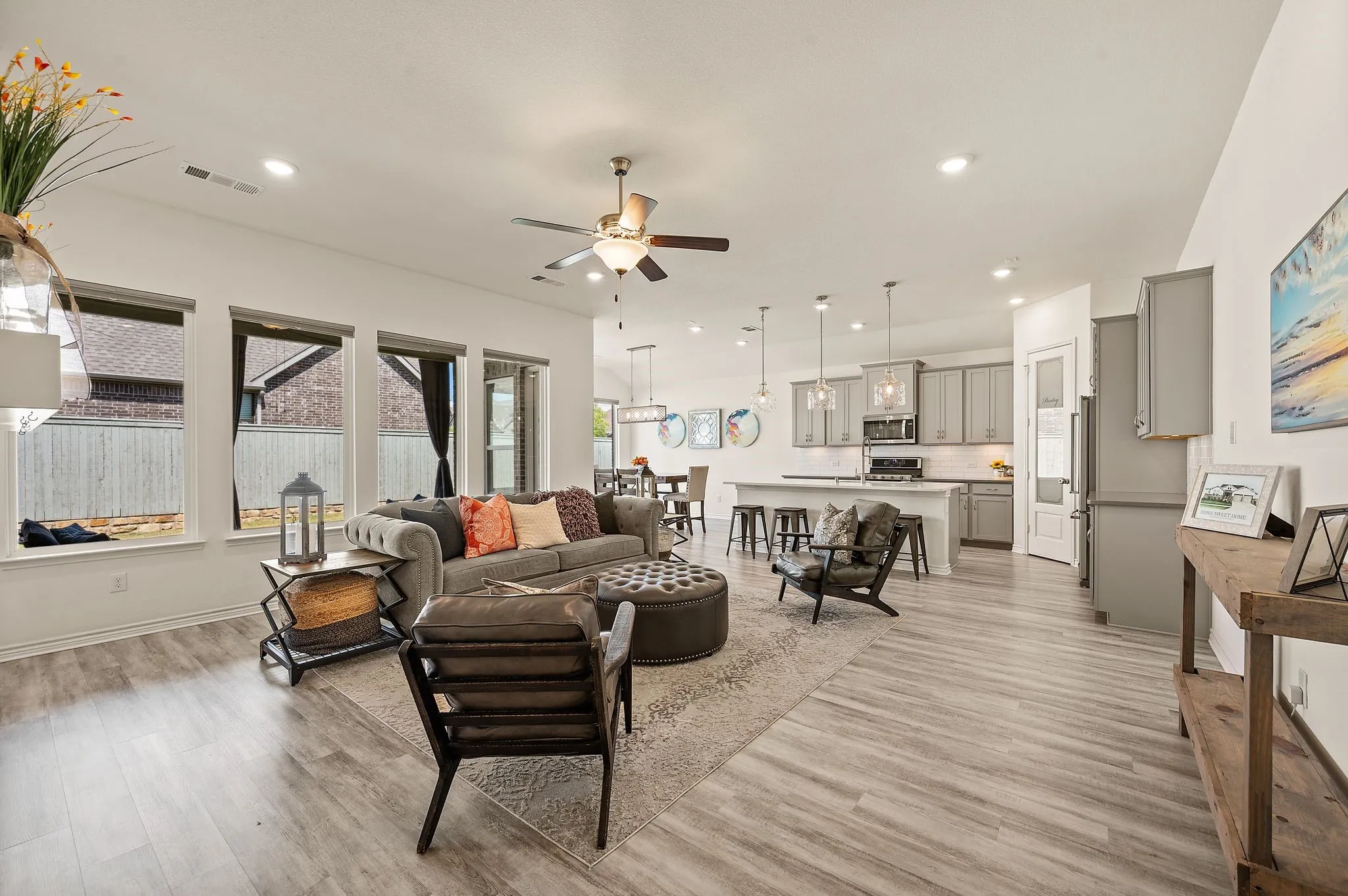 Open-concept living room featuring LVP flooring, recessed lighting, and beautiful windows that let in so much wonderful natural light!