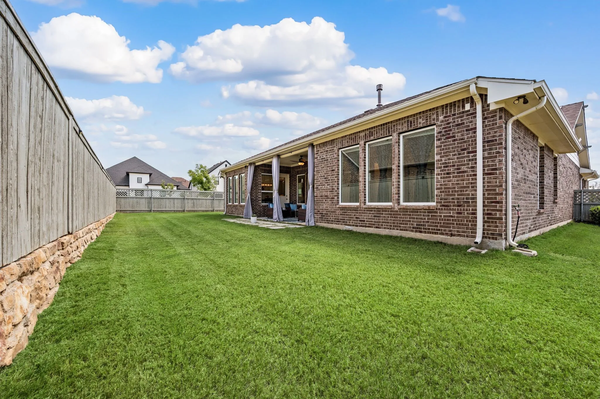 Expansive and beautiful green lawn with a wood fence and so much room for pets and your family and friends...Maybe a pool?