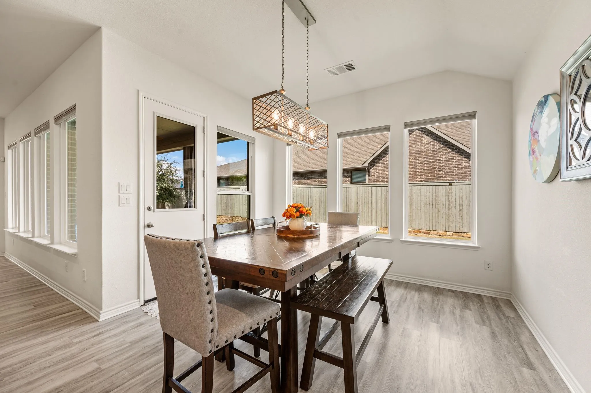 Wonderful kitchen Nook featuring high ceilings, LTV flooring, an updated chandelier, and surrounded by beautiful windows letting in natural light!