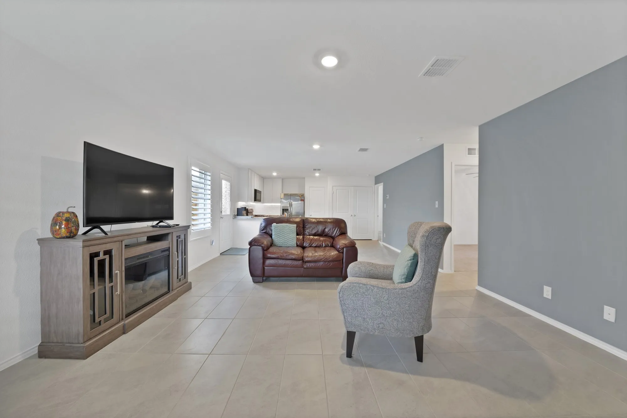 Open-concept living space with tile flooring, recessed lighting, and a neutral color palette