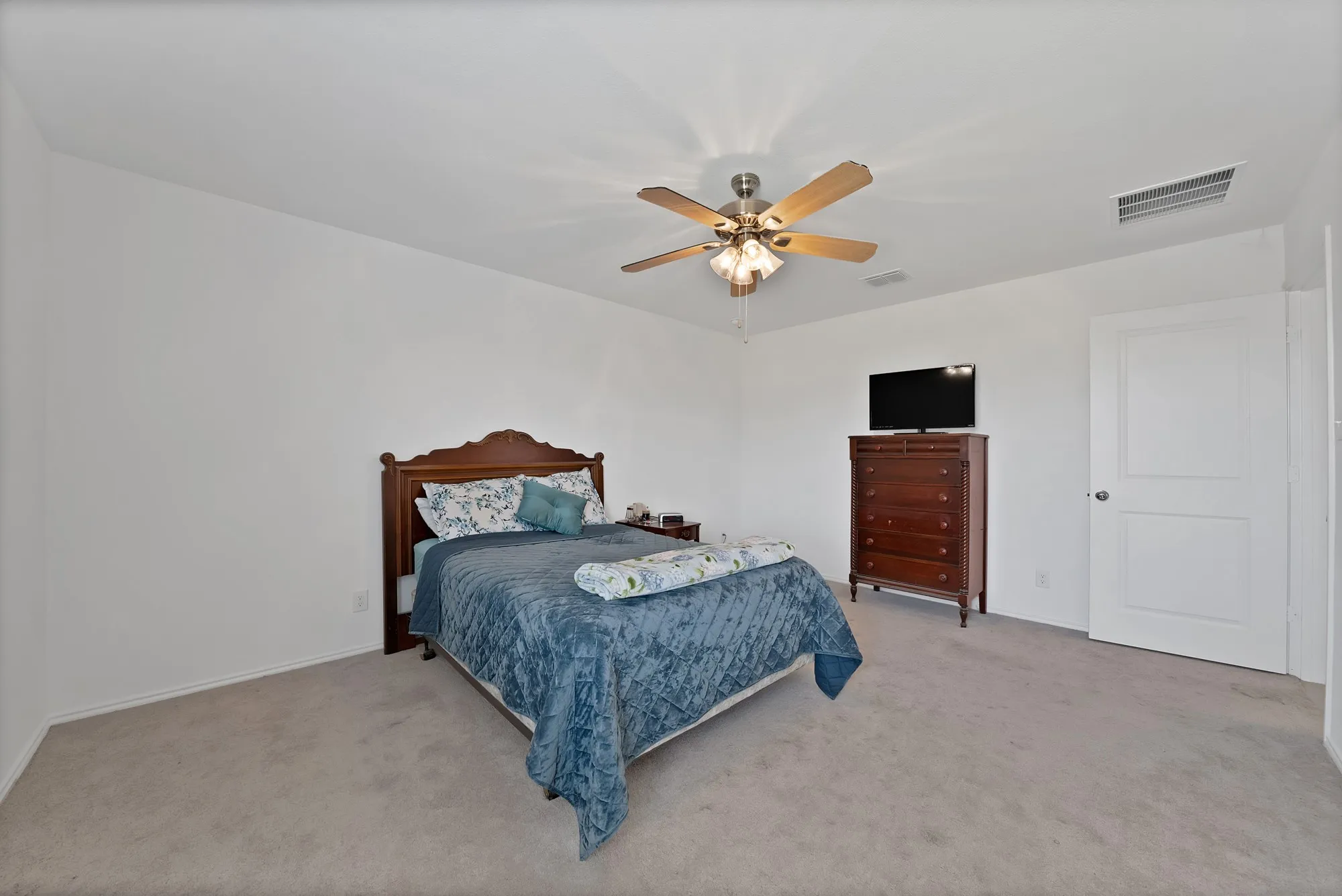 Plush carpeting and a ceiling fan with integrated lighting