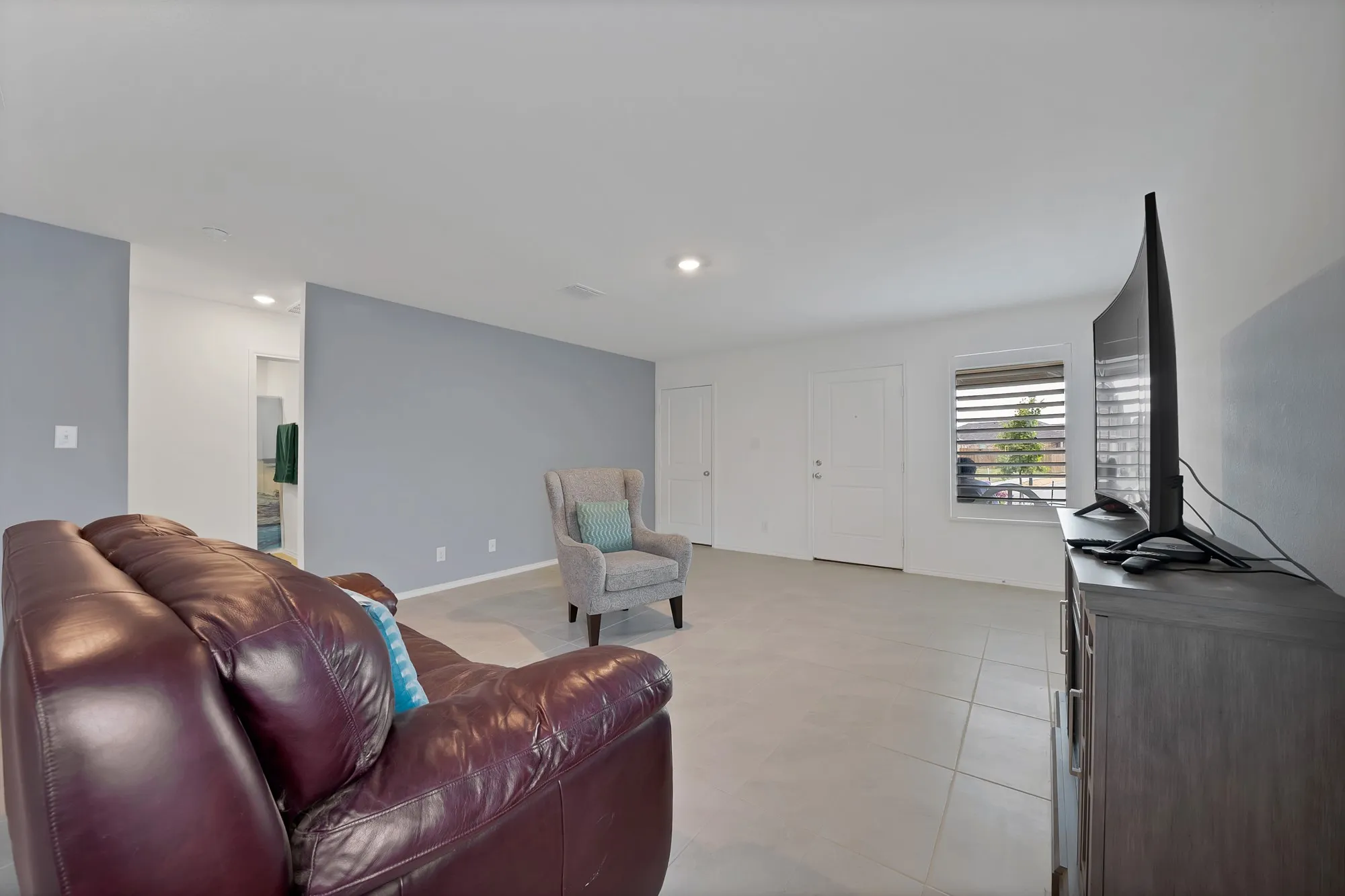 Recessed lighting, tile flooring, interior doors, and a window with horizontal blinds