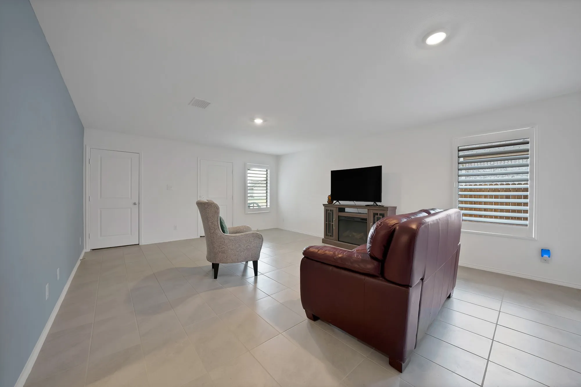 Spacious room featuring tile flooring, recessed lighting, and two panel doors