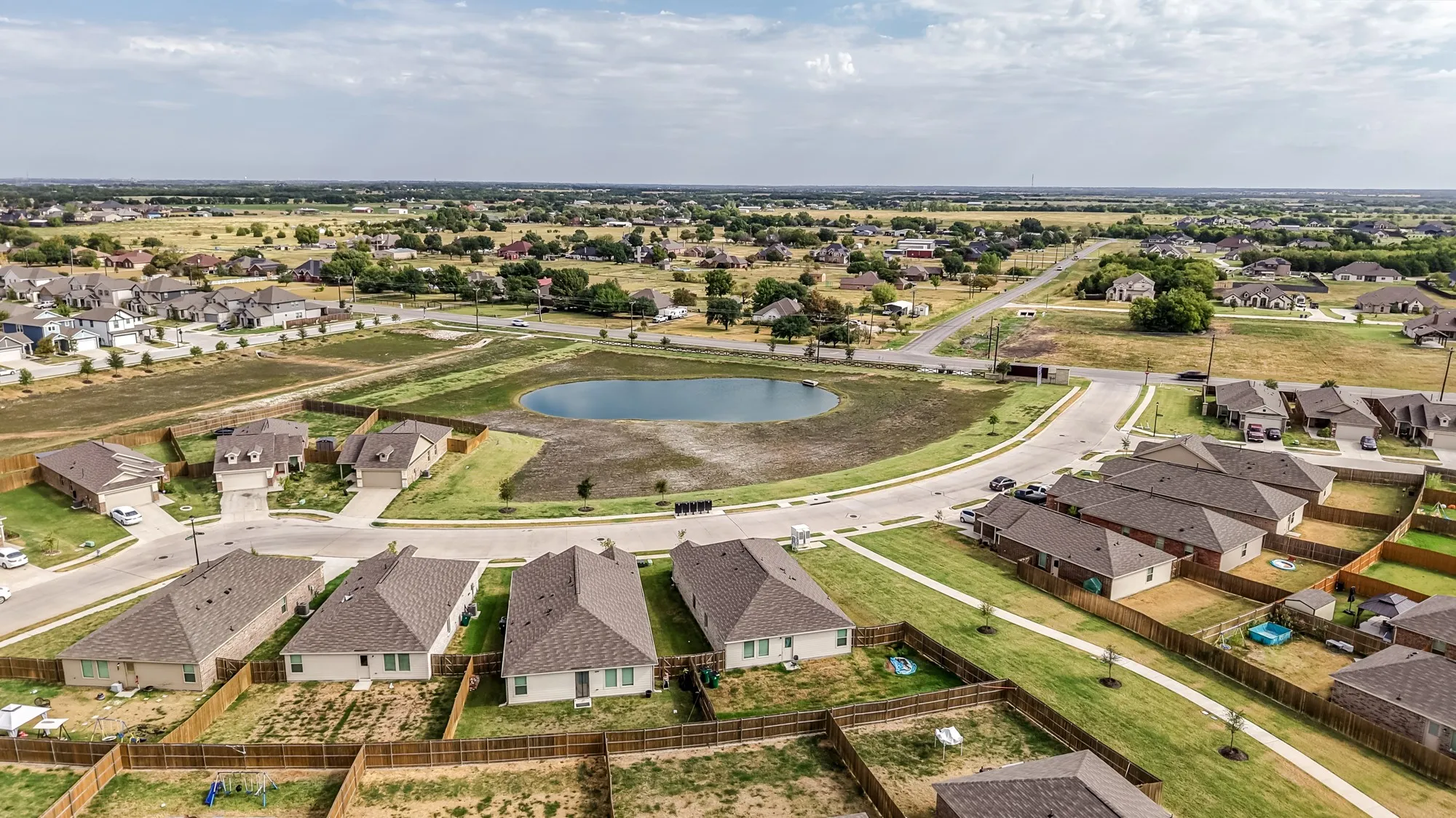 Residential properties with shingled roofs and fenced yards