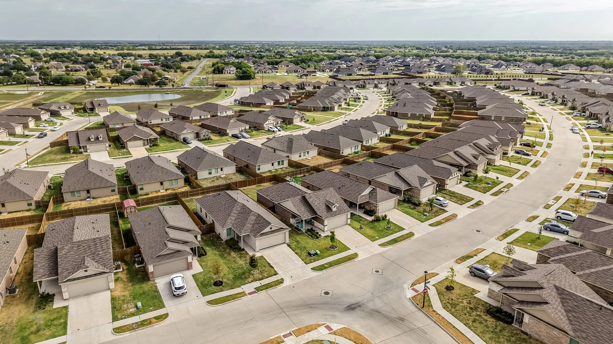 Newly developed residential community featuring consistent architectural styles, paved roadways, and uniform landscaping