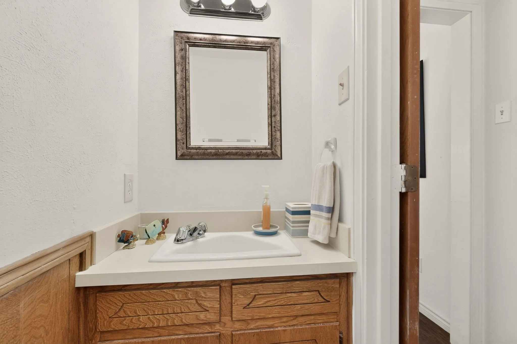 Vanity with a built-in sink, chrome faucet, and wood-finish cabinetry