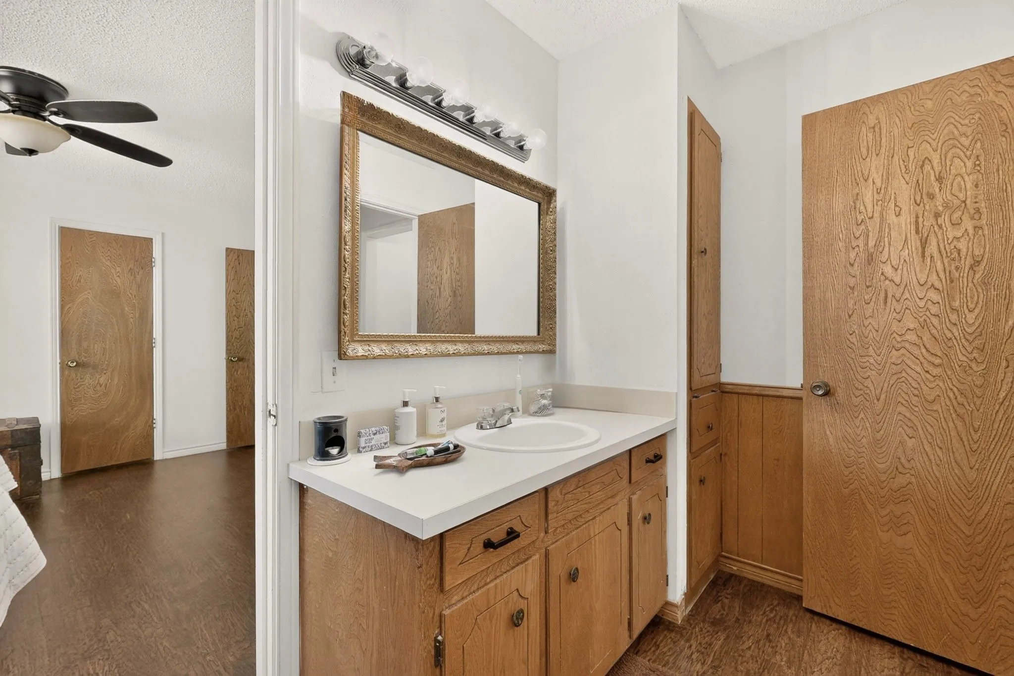 Wood-finish vanity with an integrated sink and light-colored countertop