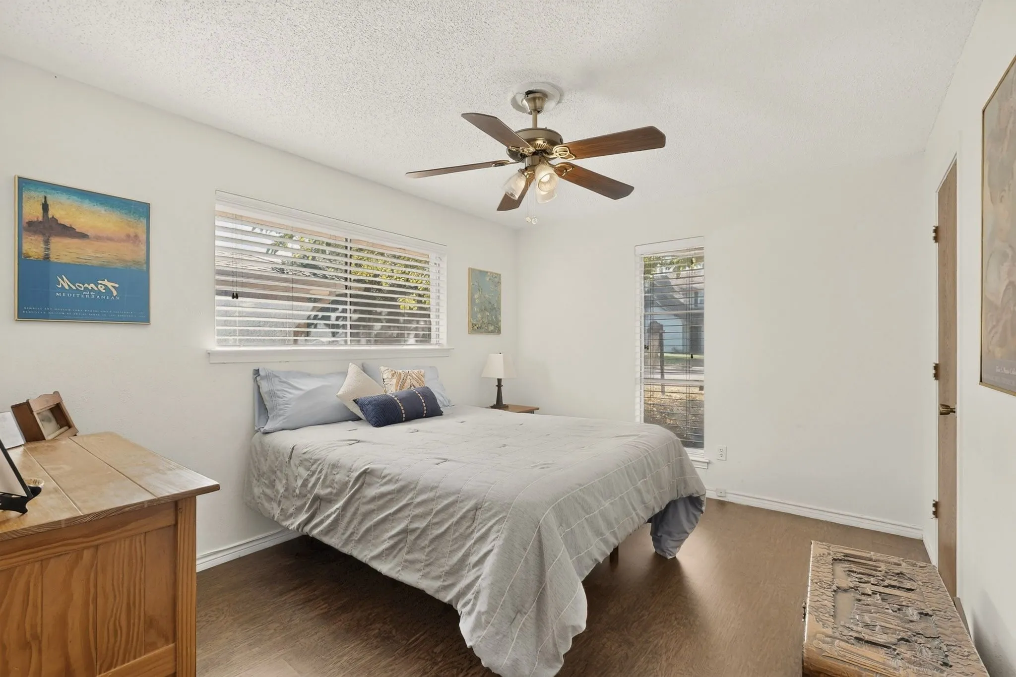 Wood-finish flooring, ceiling fan with integrated lighting, and multiple windows