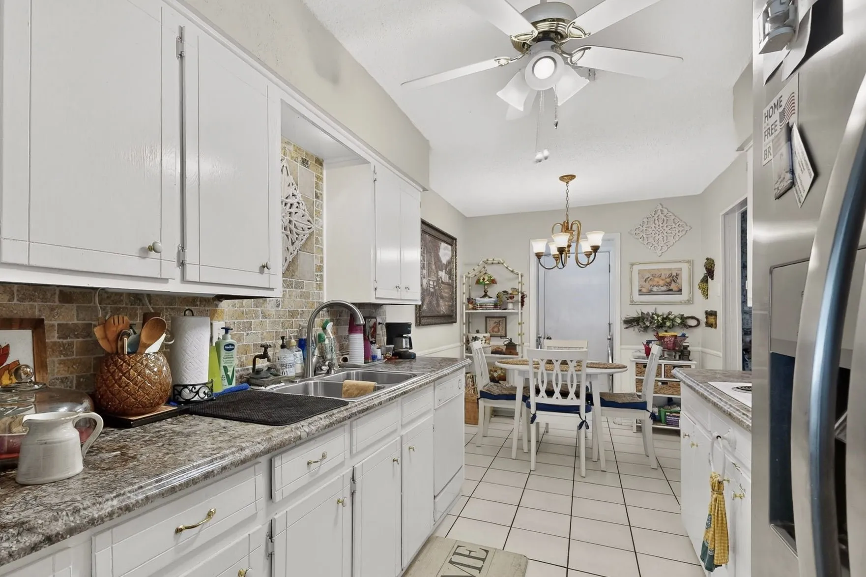 Kitchen featuring white cabinetry, a tiled backsplash, granite-style countertops, and a double basin sink