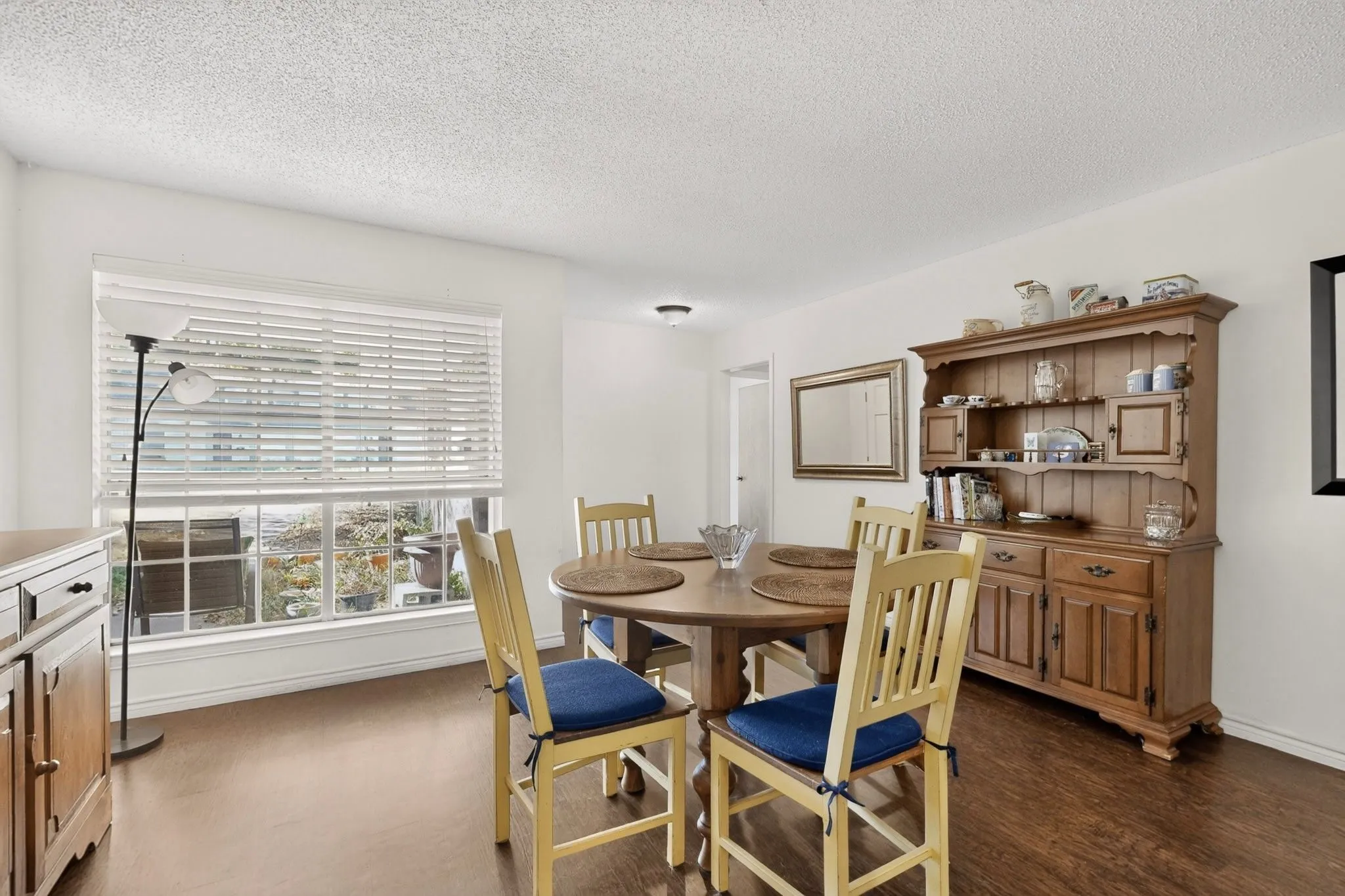 Hardwood-finish flooring, white walls, and a large window with blinds